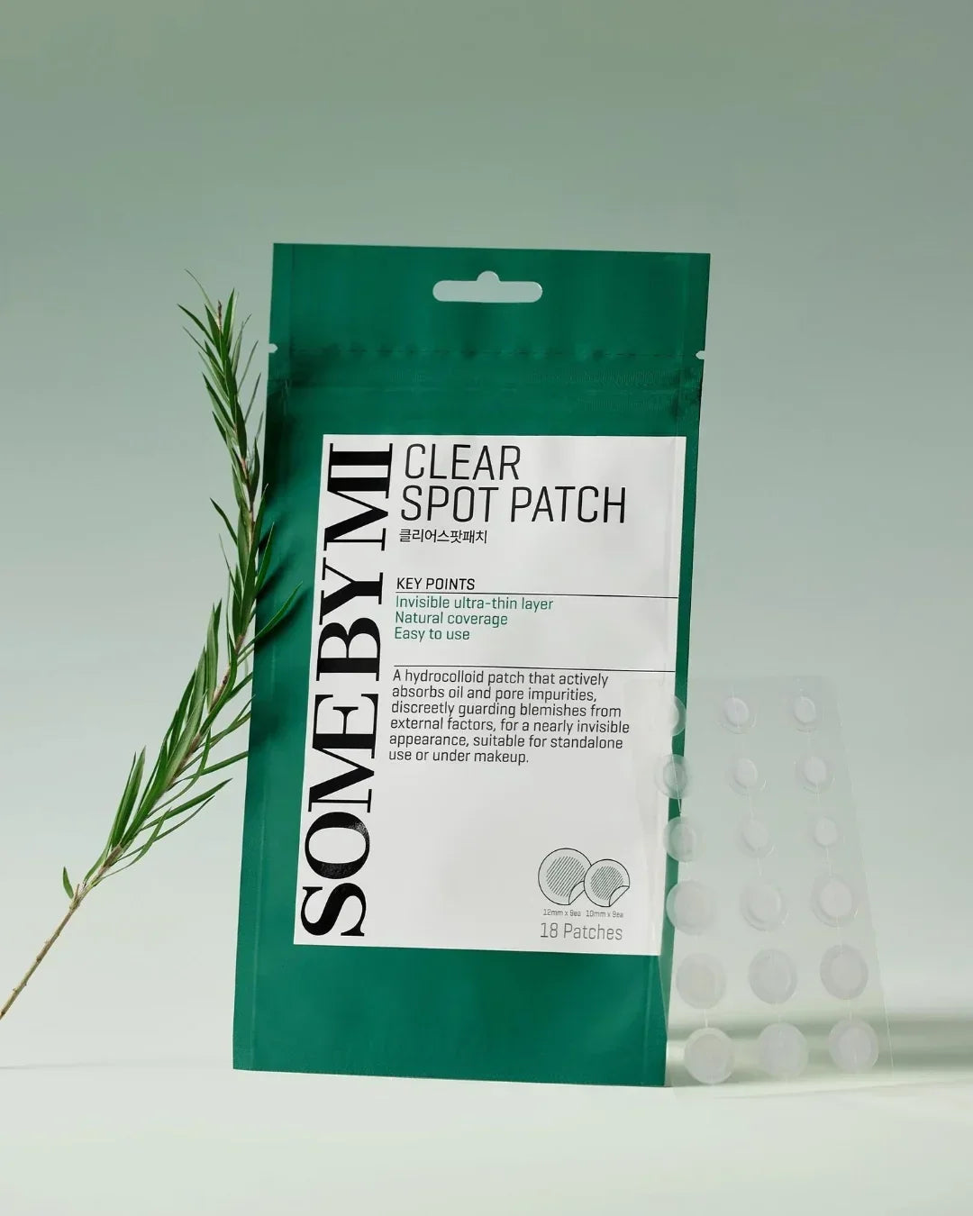 SOMEBYMI Clear Spot Patch package with 18 hydrocolloid acne patches and green plant on light background