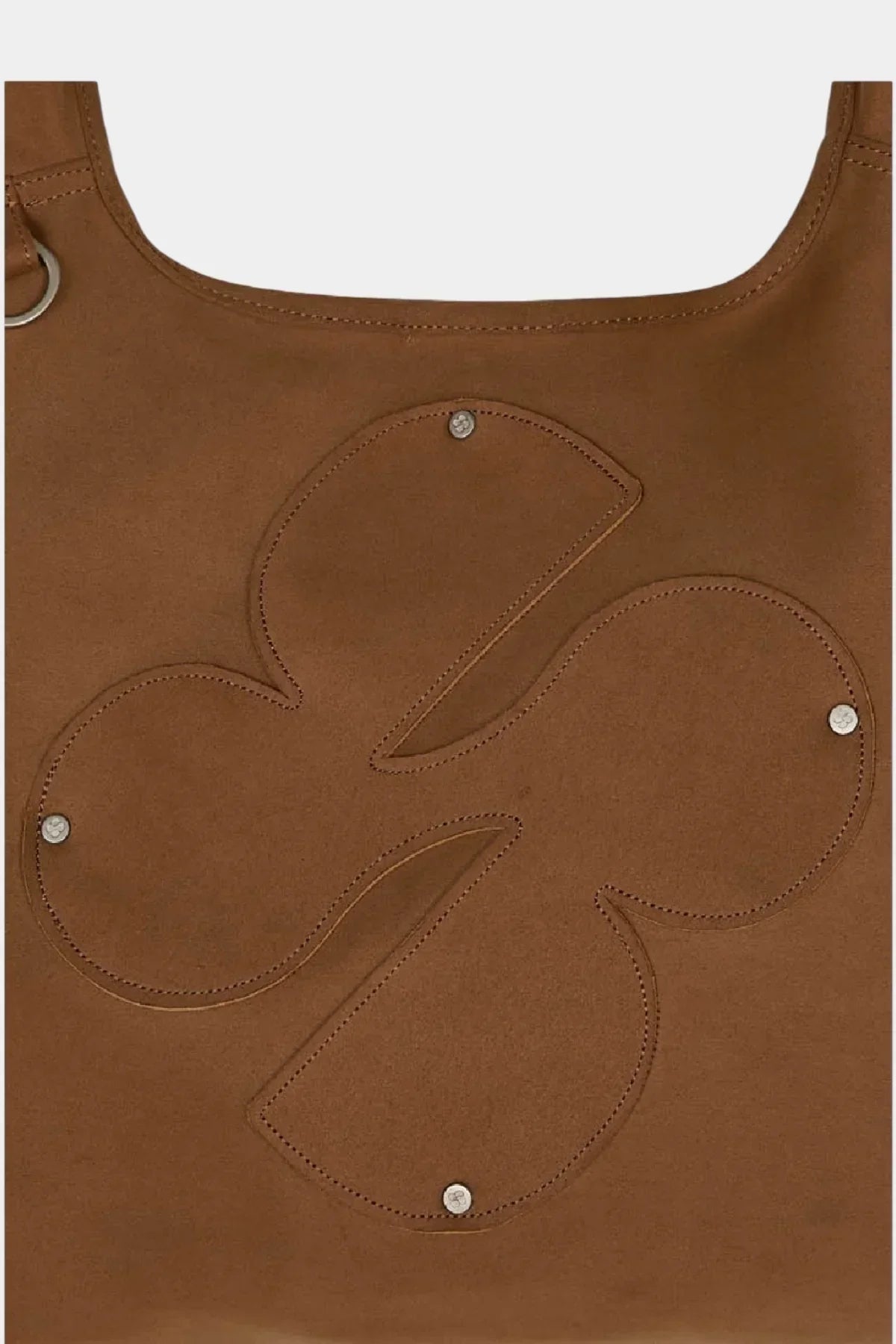 Close-up of camel artificial suede shoulder bag with stitched clover logo and metal studs