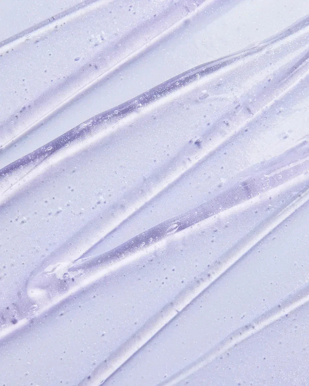 Close-up of translucent lavender collagen brightening eye gel cream texture with bubbles