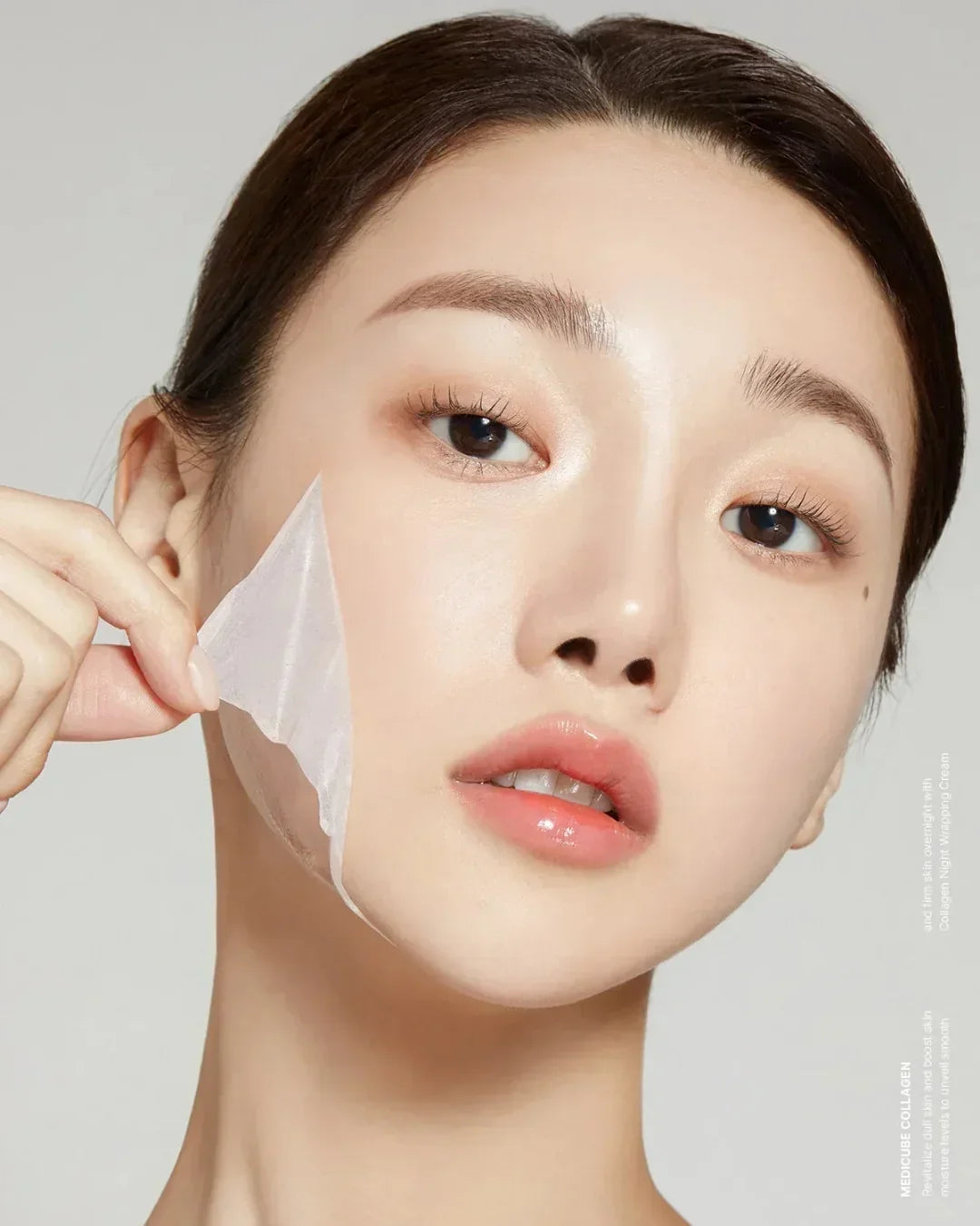 Close-up of woman peeling off translucent collagen night mask from smooth glowing skin
