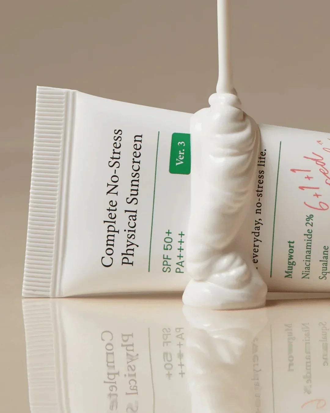 Tube of Complete No-Stress Physical Sunscreen SPF 50+ PA++++ with cream dispensed on beige surface