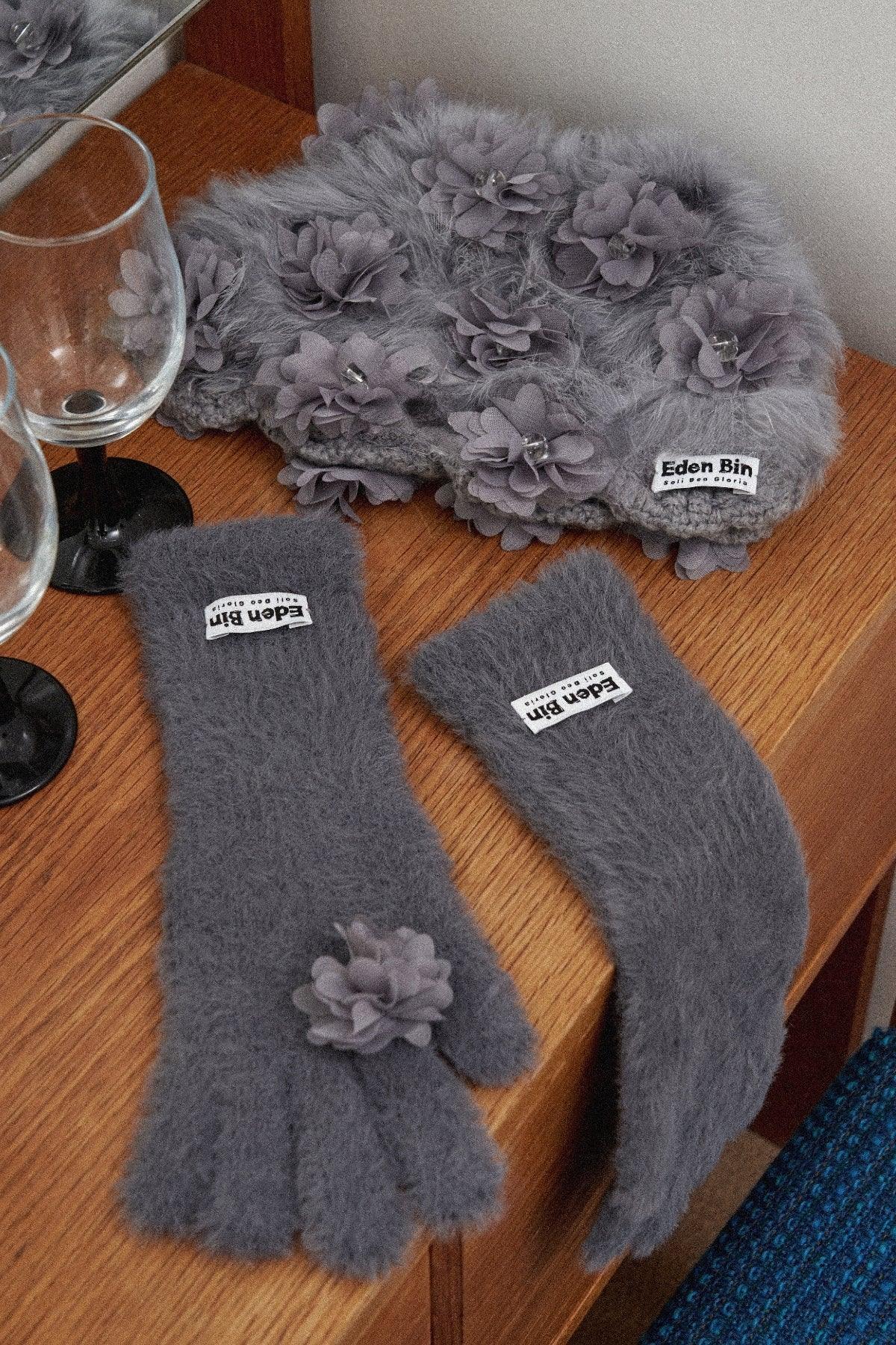 Grey mink fur crochet beanie with flower appliques and matching fuzzy fingerless gloves on wooden surface