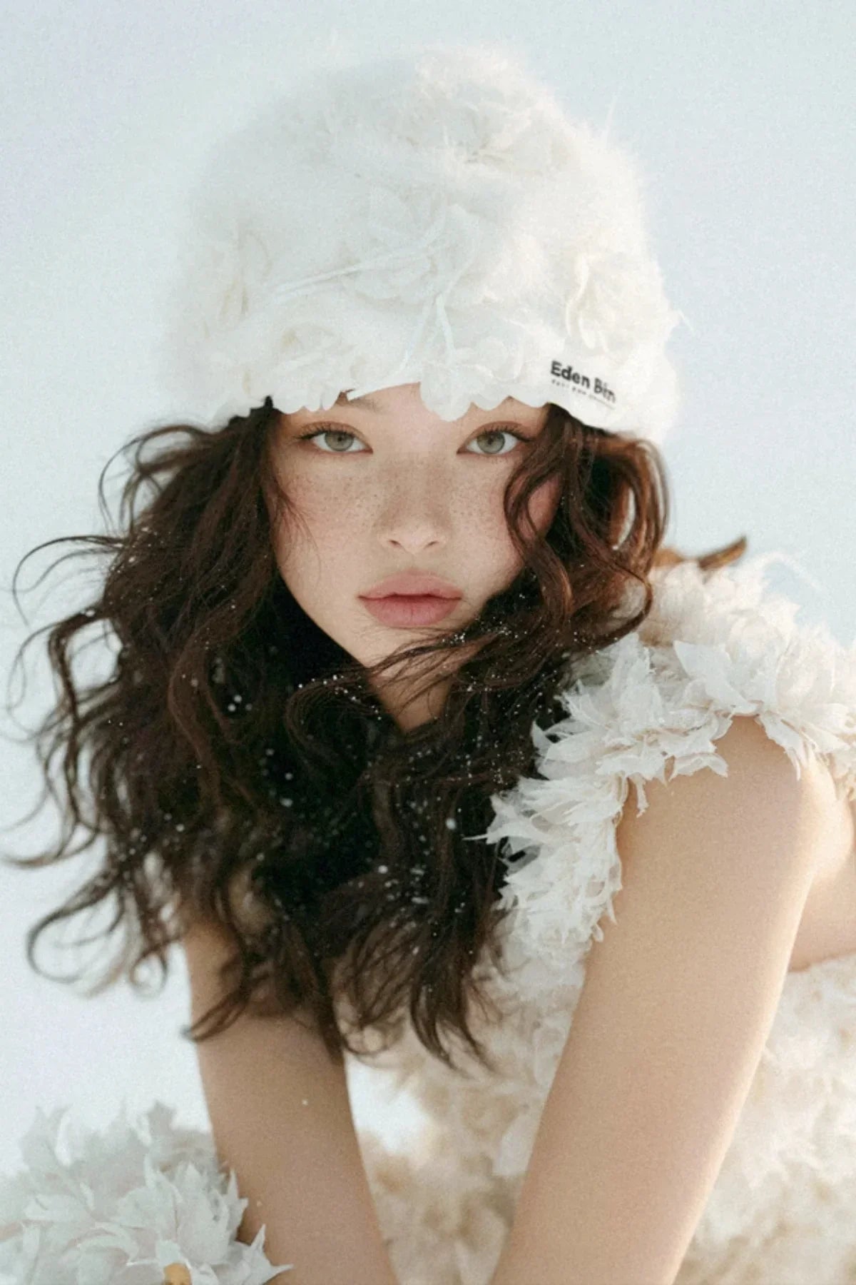 Model wearing white couture flower applique mink fur crochet beanie and matching textured top