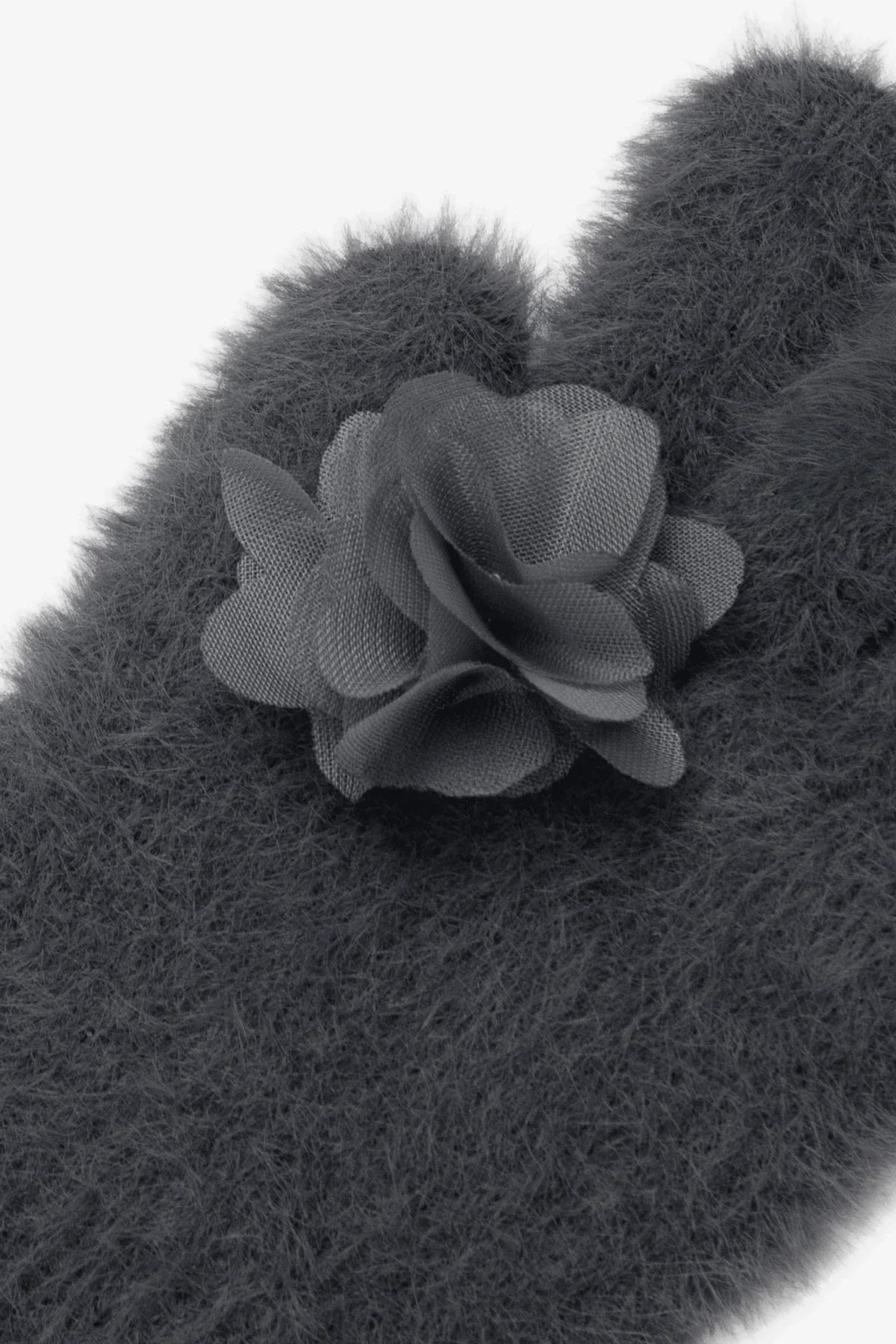 Close-up of fuzzy grey ring gloves with a detailed fabric flower applique