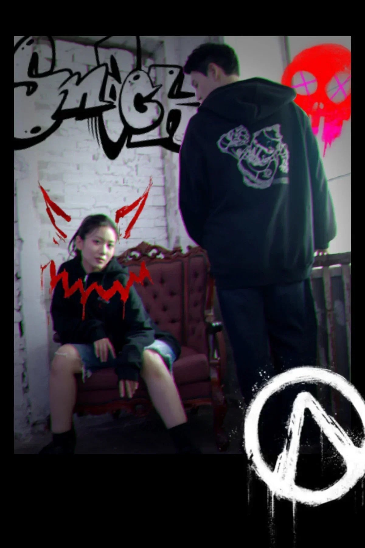 Two people wearing black hoodies with graphic designs in an urban setting with graffiti and red face paint effects