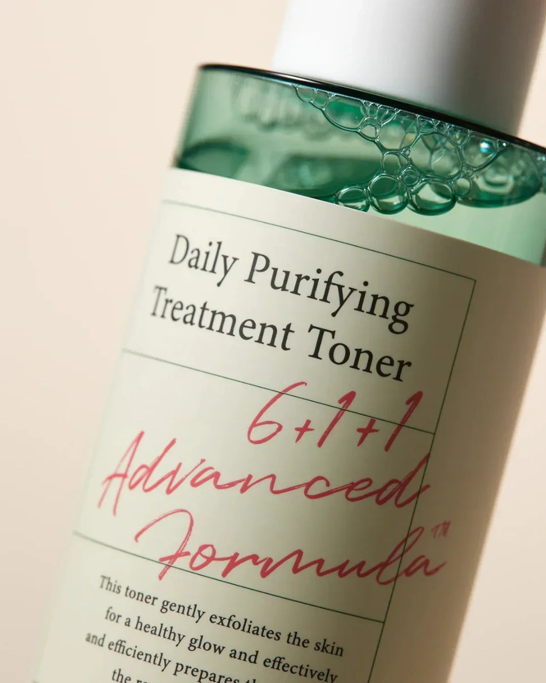 Close-up of Daily Purifying Treatment Toner bottle with green liquid and bubbles