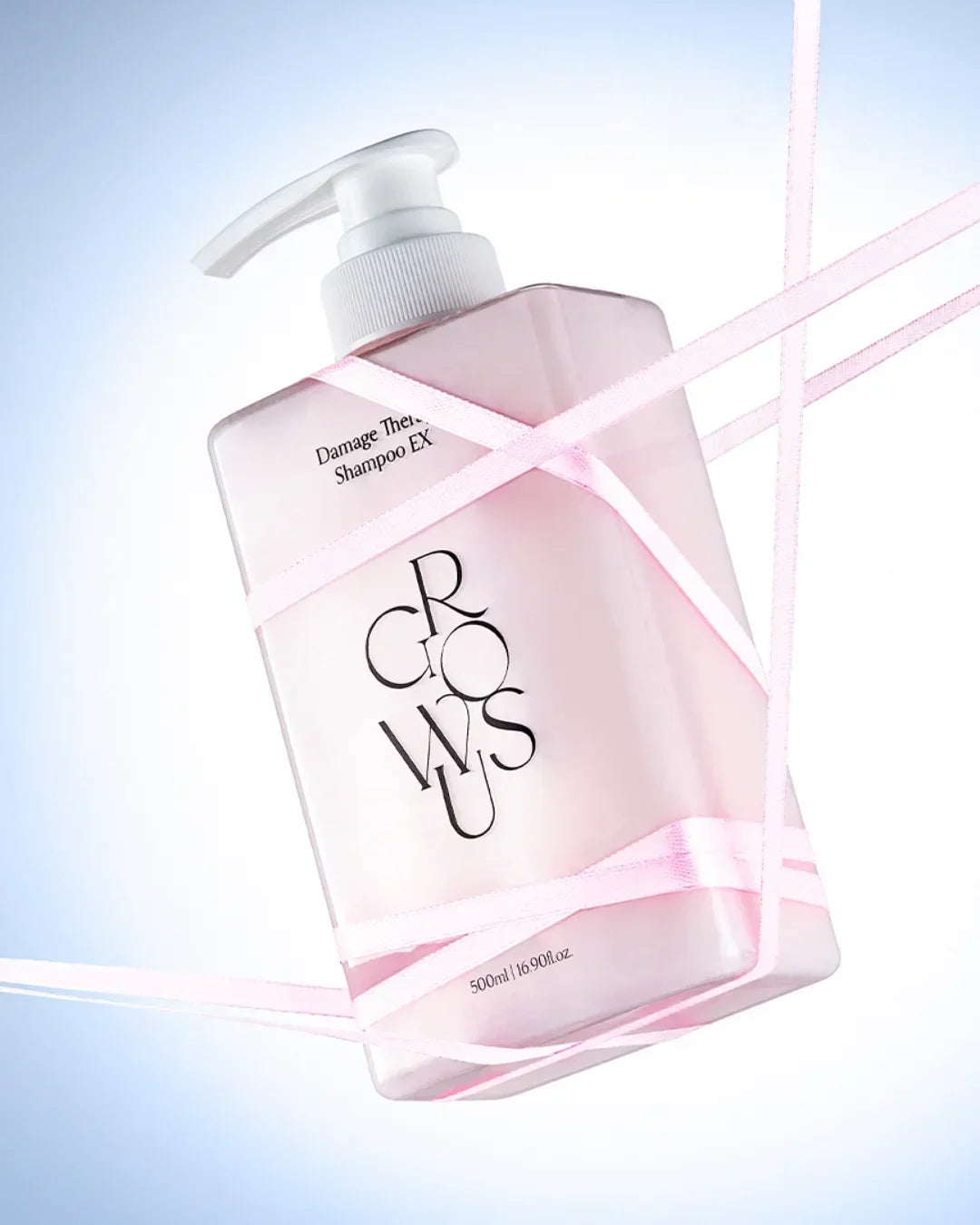 Pink 500ml Damage Therapy Shampoo EX bottle with pump on light blue background wrapped with pink ribbons
