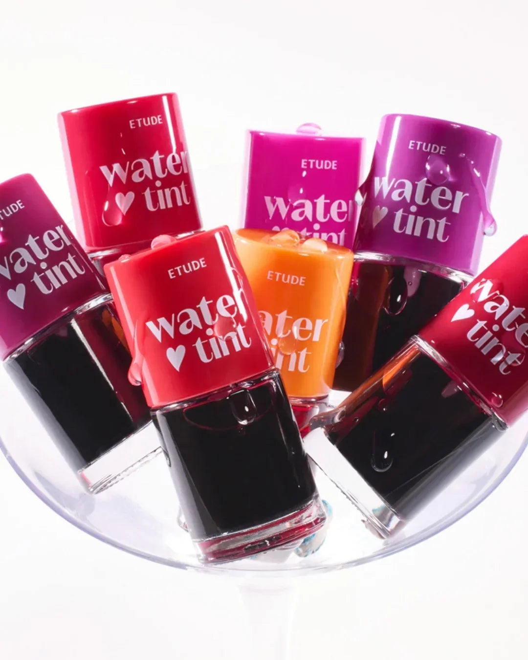 Colorful Etude water tint lip stains in red, purple, orange displayed in a clear glass bowl