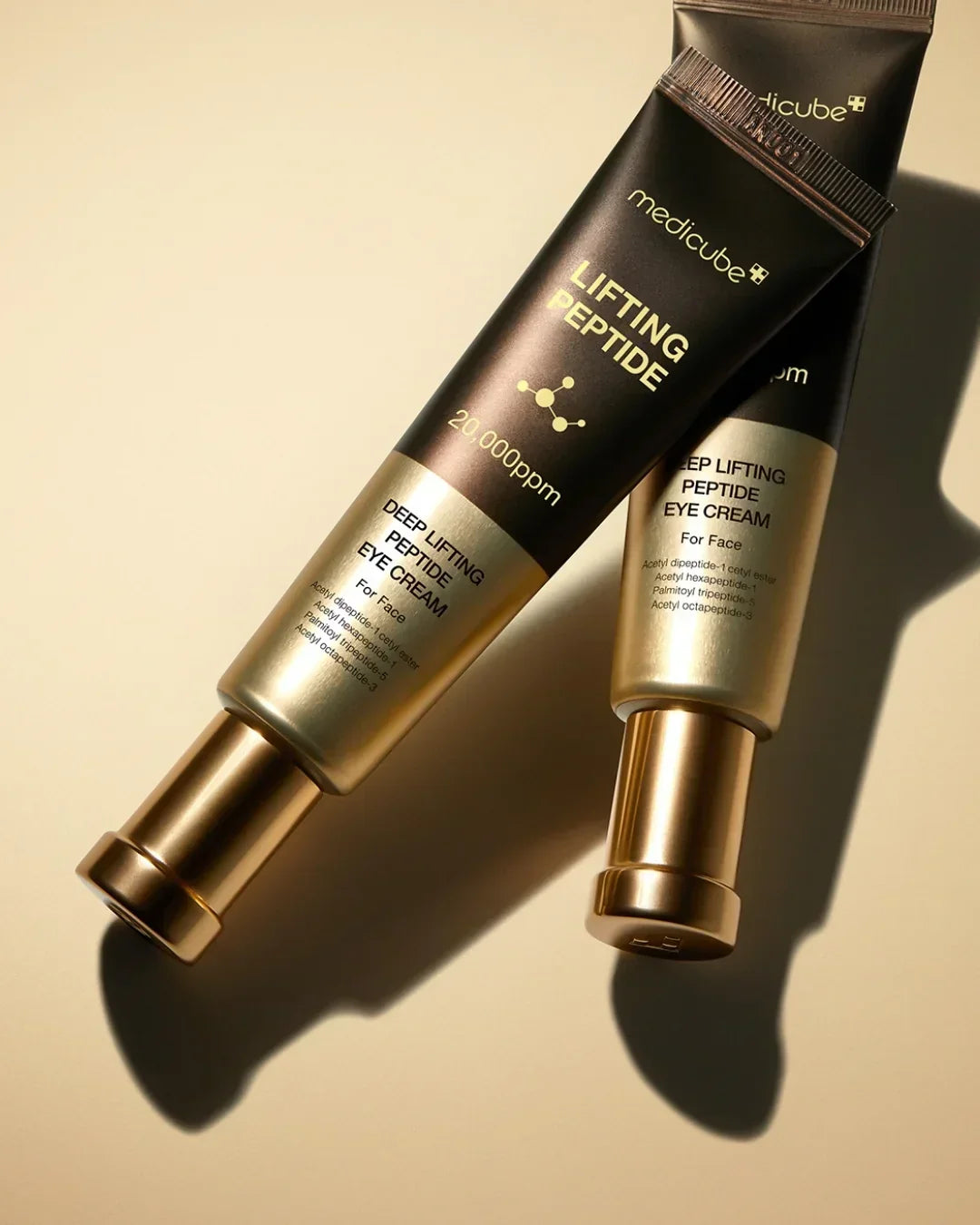 Medicube Lifting Peptide Deep Lifting Peptide Eye Cream tubes on beige background