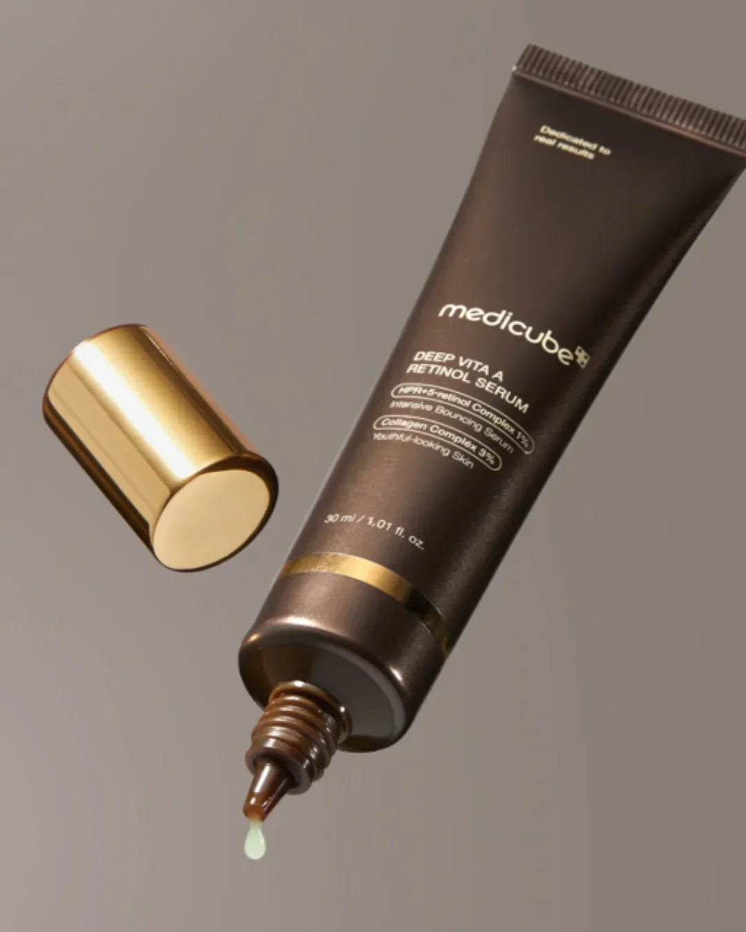 Medicube Deep Vita A Retinol Serum tube with gold cap and serum drop on neutral background