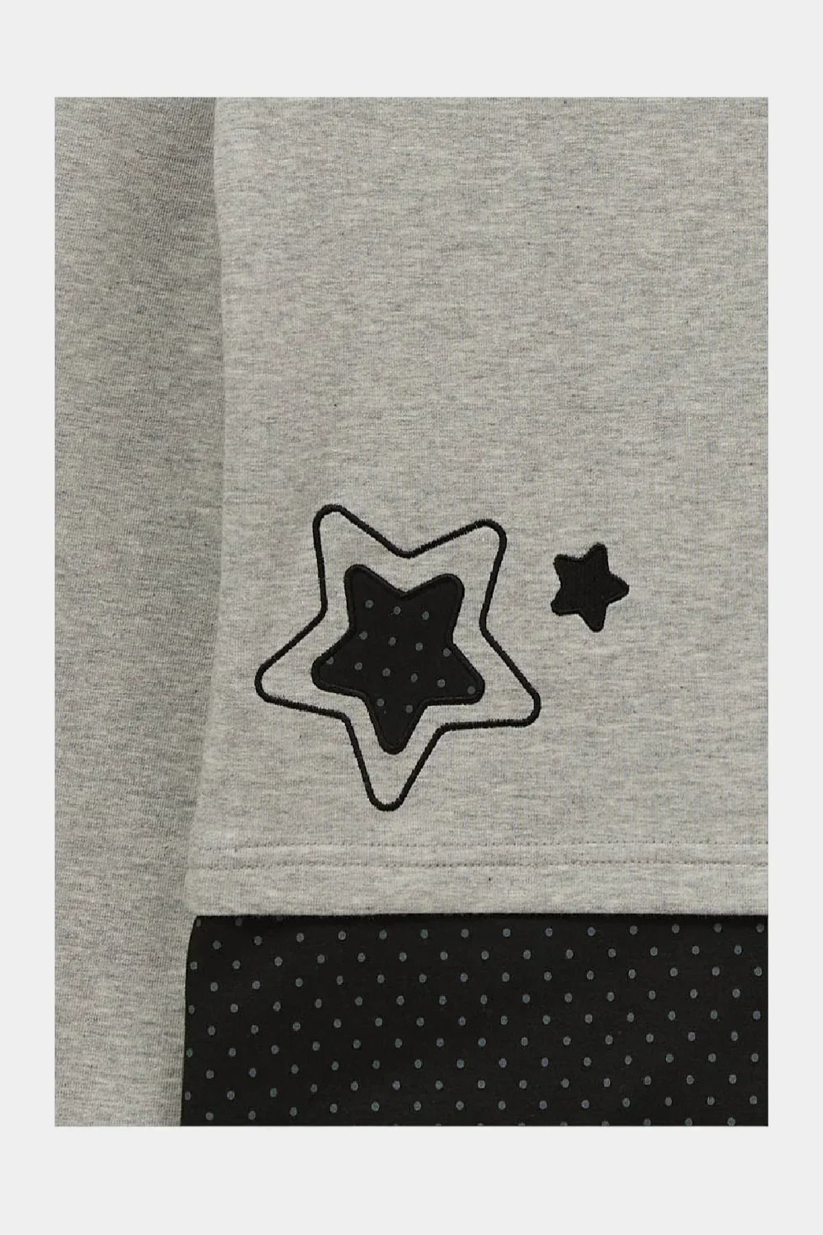 Grey long sleeve t-shirt detail with black star applique and polka dot layered fabric