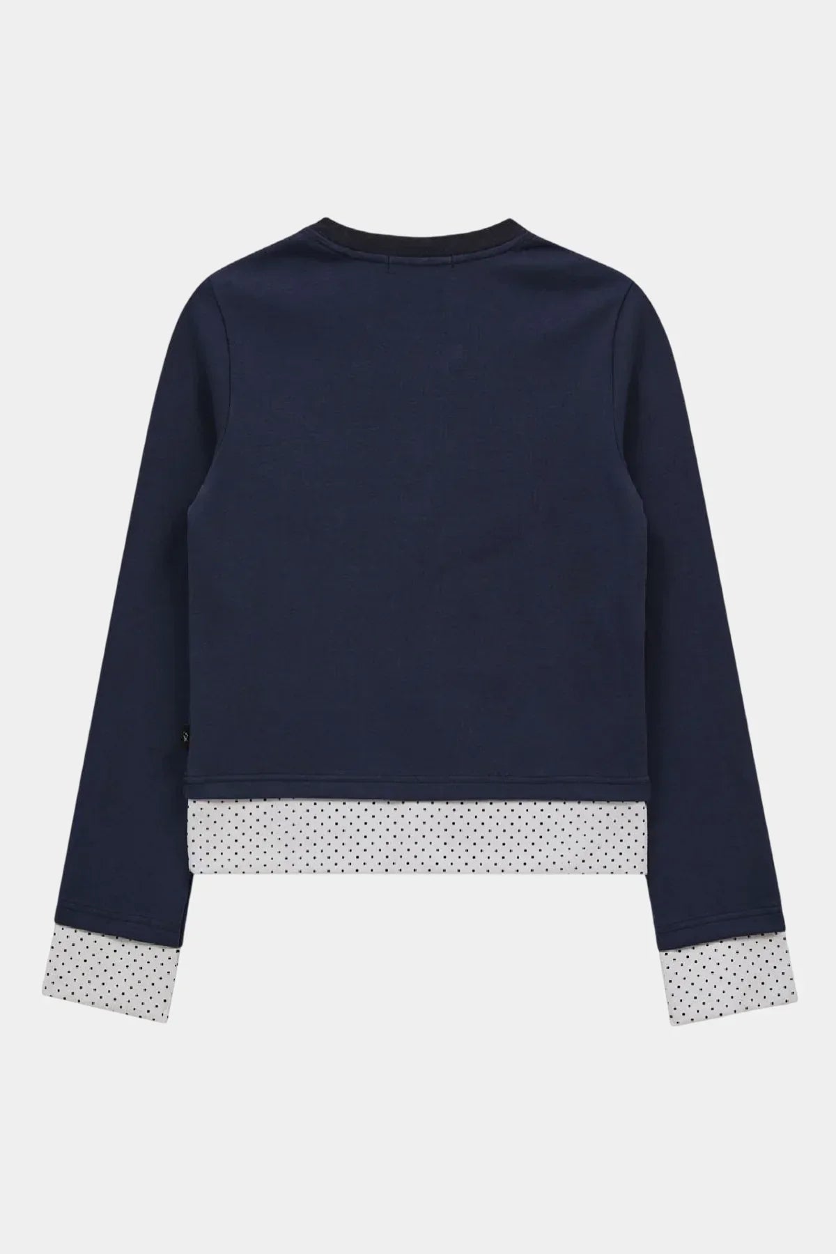 Back view of navy blue long sleeve layered t-shirt with white polka dot cuffs and hem