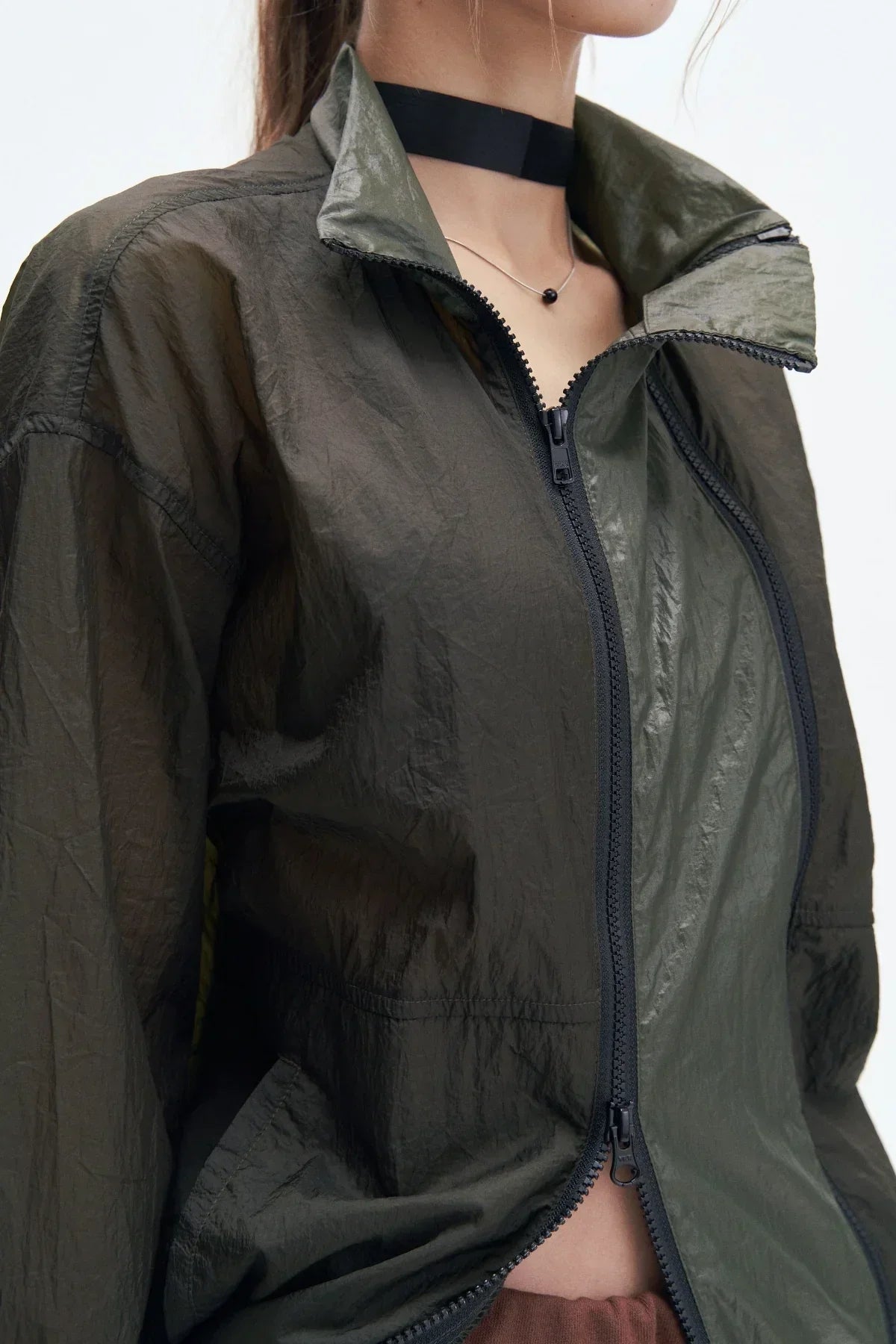 Close-up of black double zipper windbreaker jacket with high collar on model