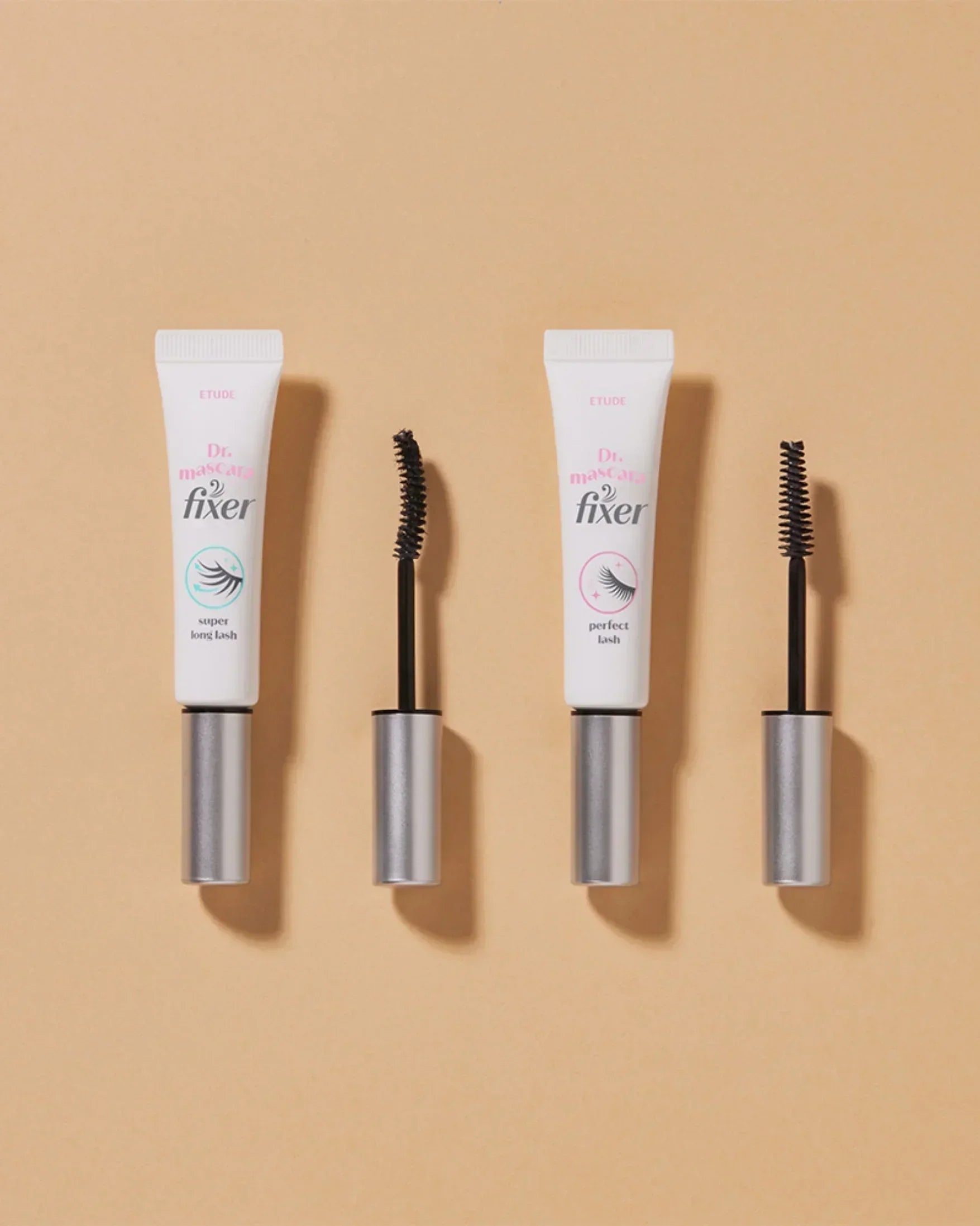 Two tubes of Etude Dr. Mascara Fixer with open mascara wands on beige background, super long lash and perfect lash