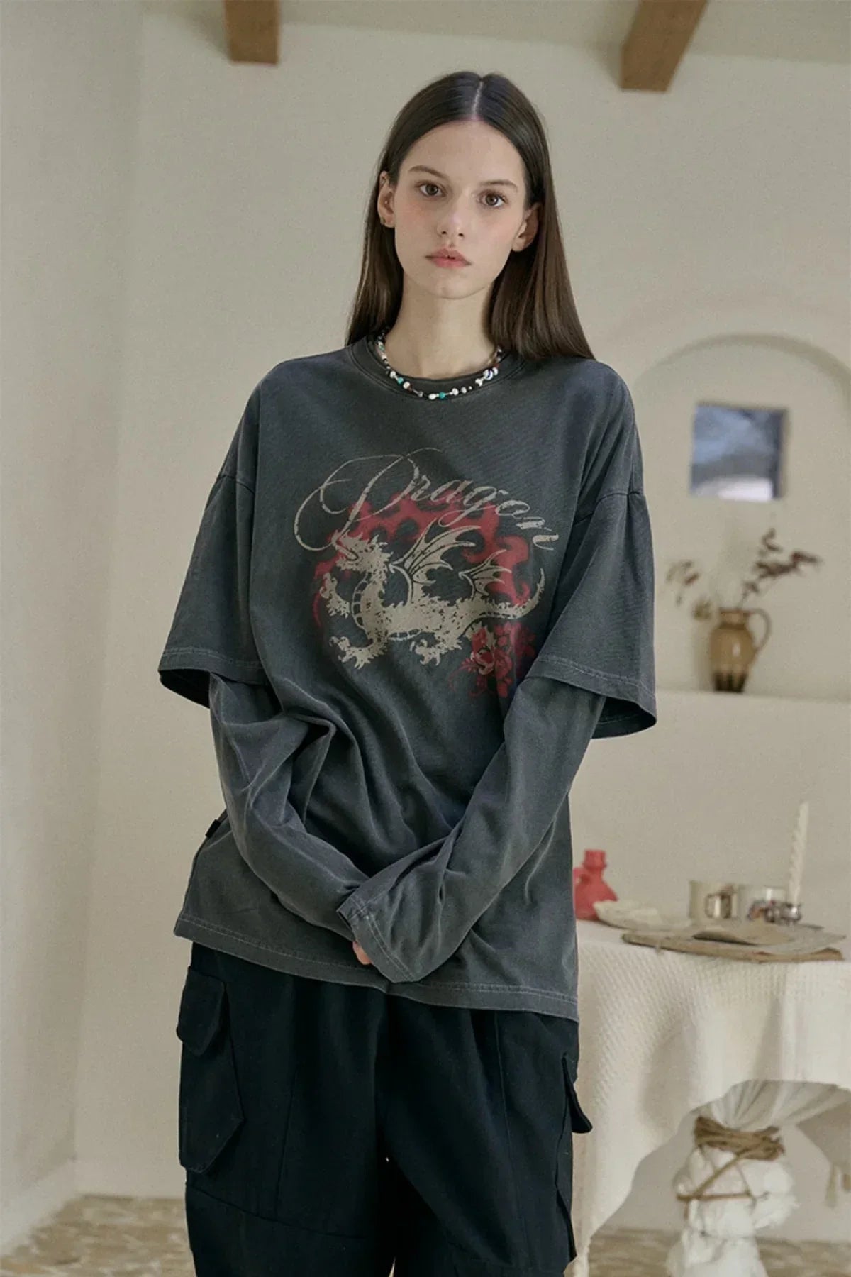 Woman wearing smoke black long sleeve layered dragon print T-shirt in neutral indoor setting