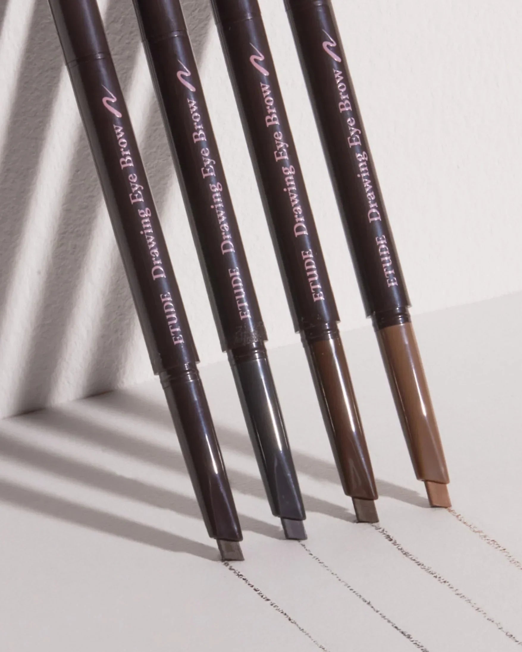 Four Etude Drawing Eye Brow pencils in varying brown shades with clear strokes on a white surface
