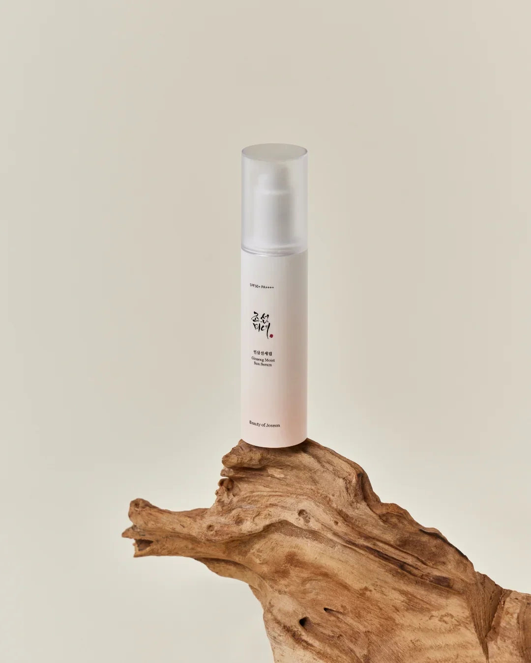 Ginseng Moist Sun Serum SPF50 PA++++ bottle on natural driftwood with beige background