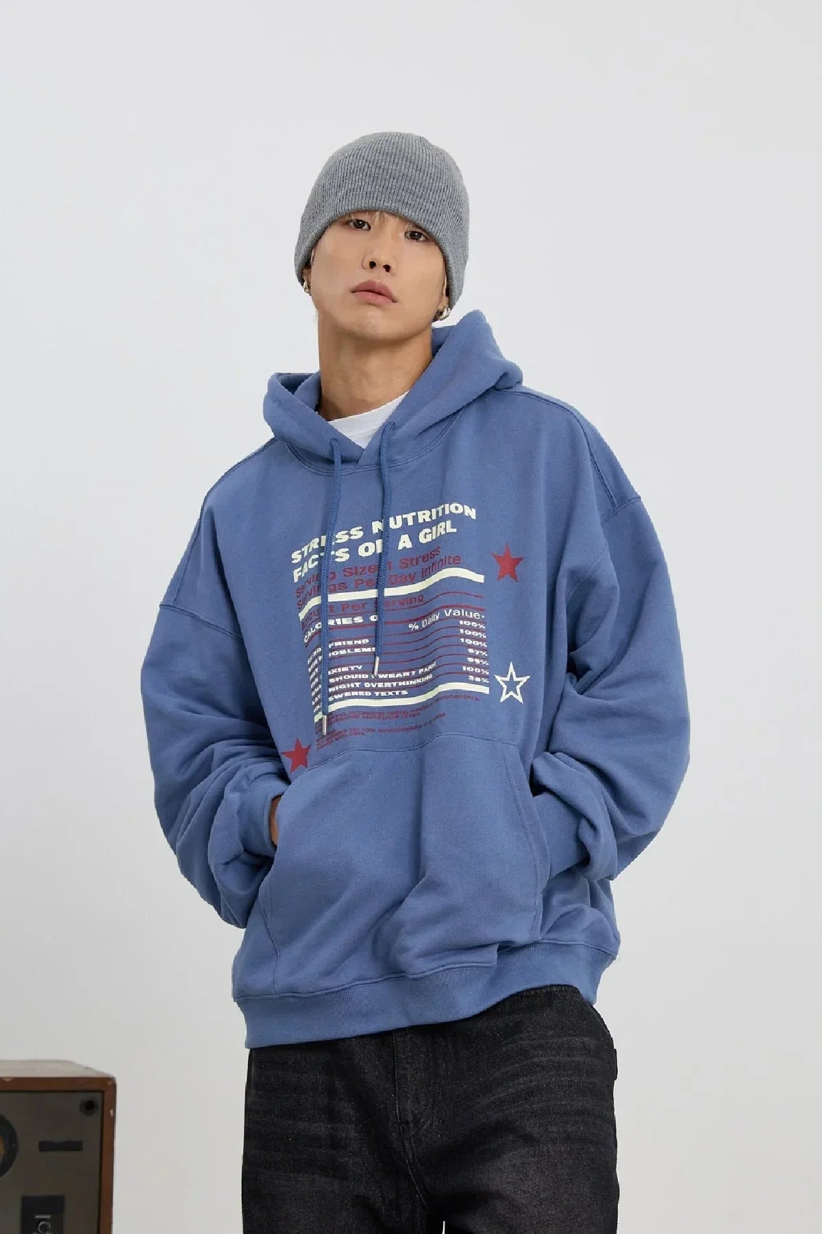 Man wearing dust blue graphic hoodie with stress nutrition text and gray beanie