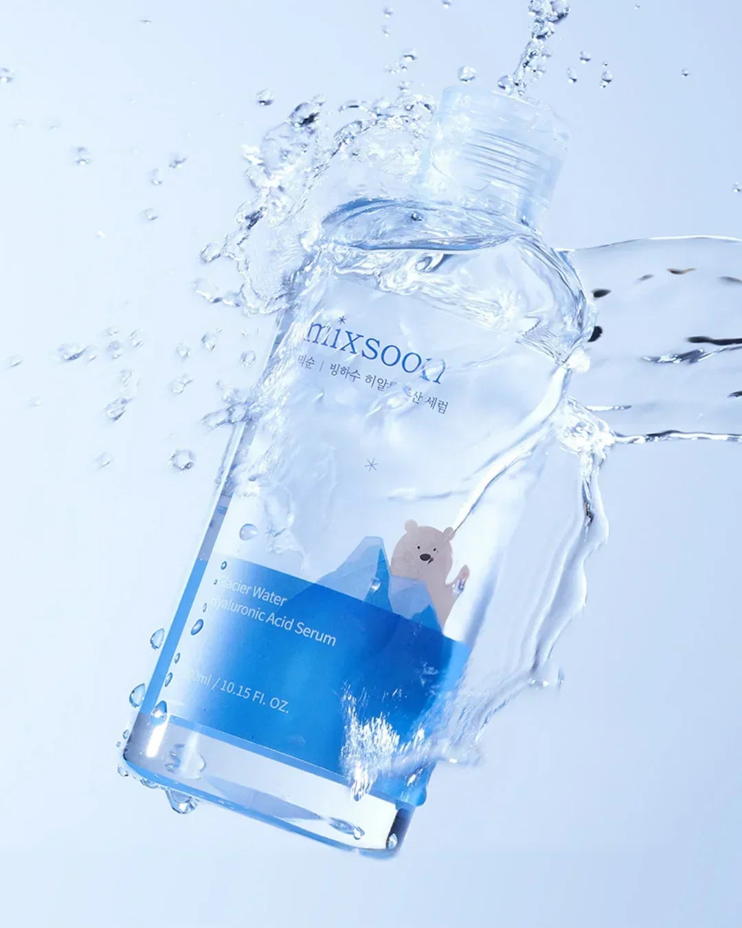 Mixsoon Glacier Water Hyaluronic Acid Serum 100ml bottle splashed with water on light blue background