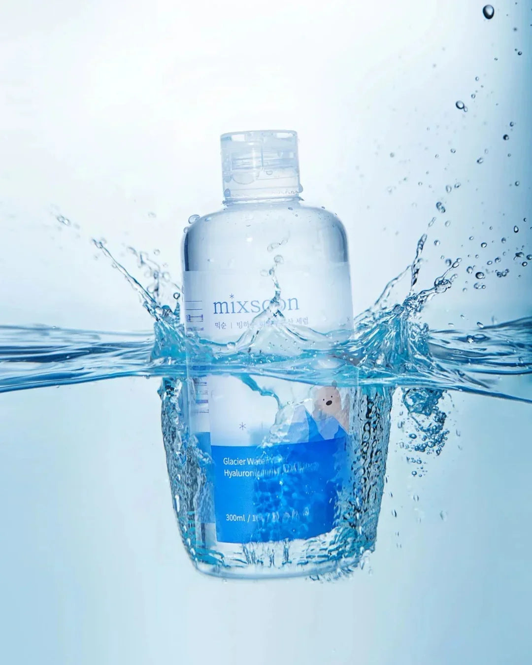 Mixsoon Glacier Water Hyaluronic Acid Serum bottle splashing into clear water with blue background