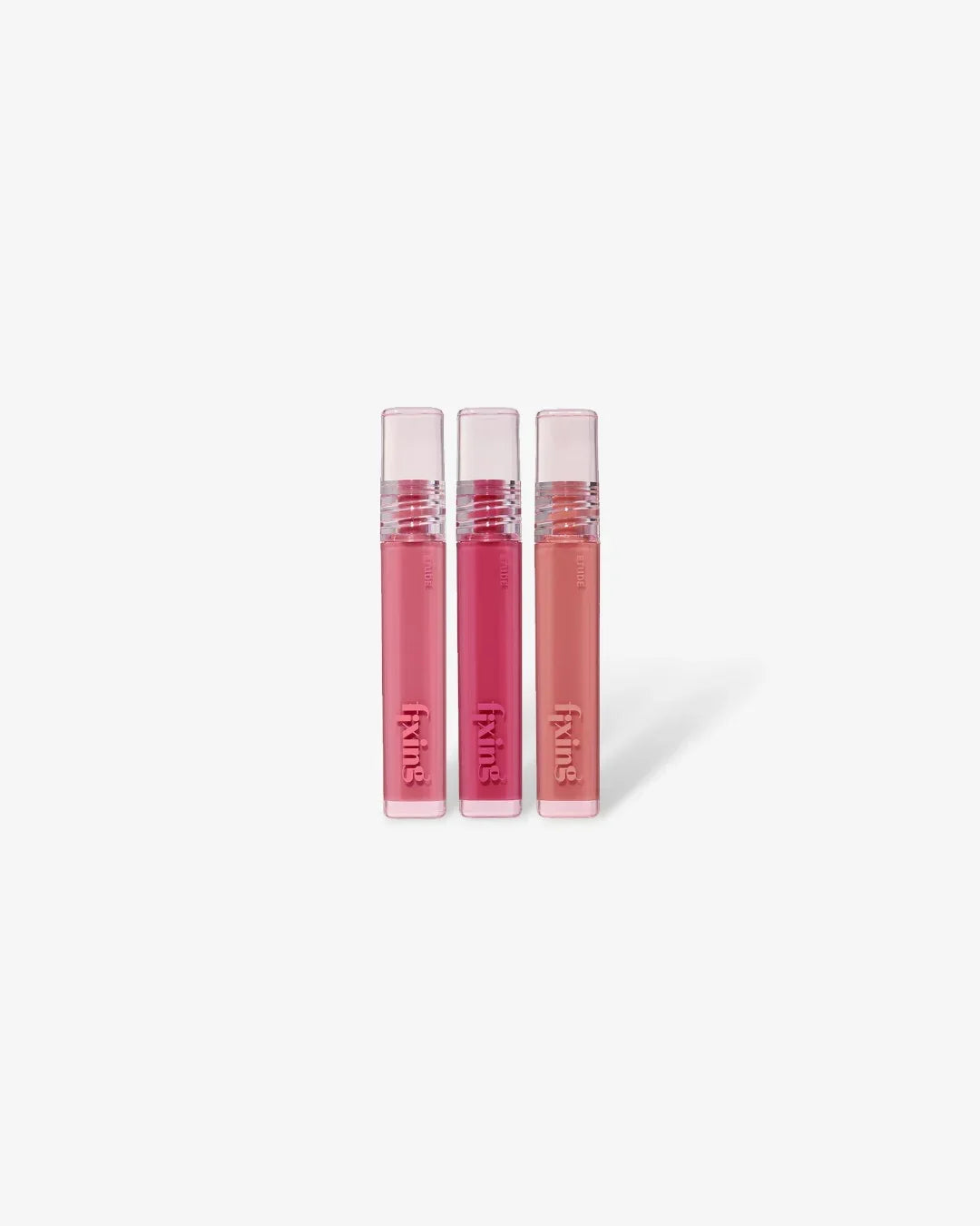 Three pink and peach glow fixing tint lipsticks on white background