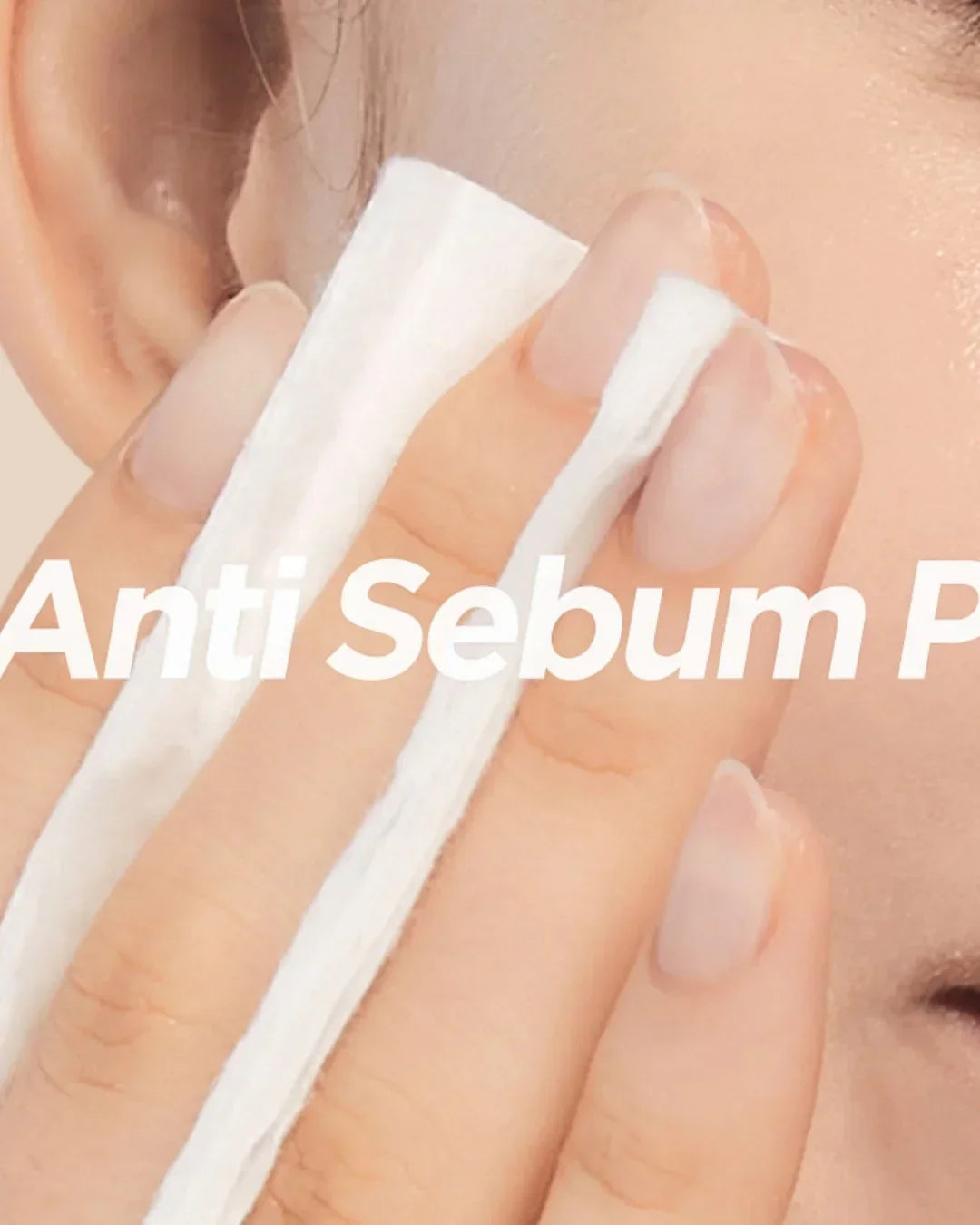 Close-up of a person using a white cotton pad on oily skin near the ear, highlighting anti sebum care