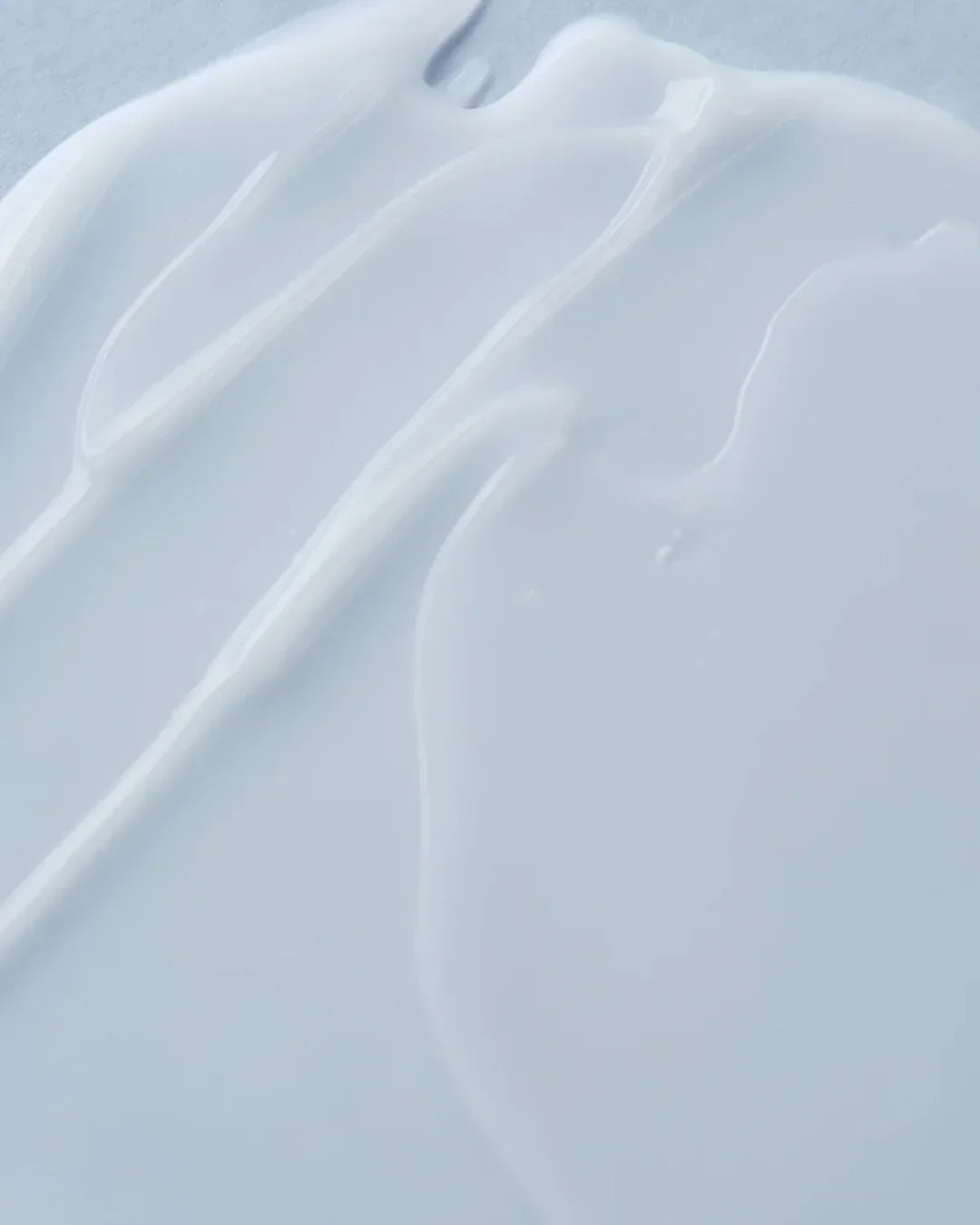 Close-up of smooth, white calming cream texture on a light surface