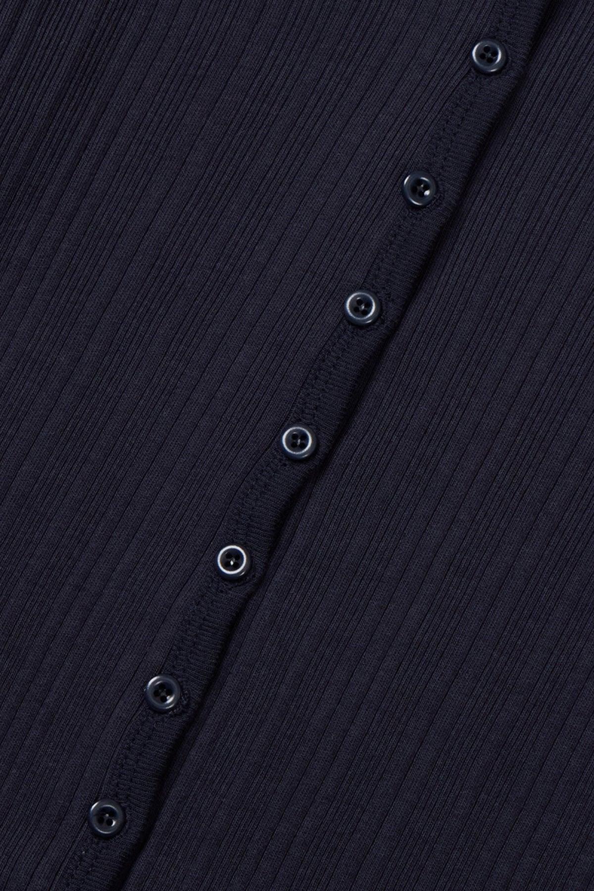 Close-up of navy blue ribbed fabric cardigan with a row of dark buttons