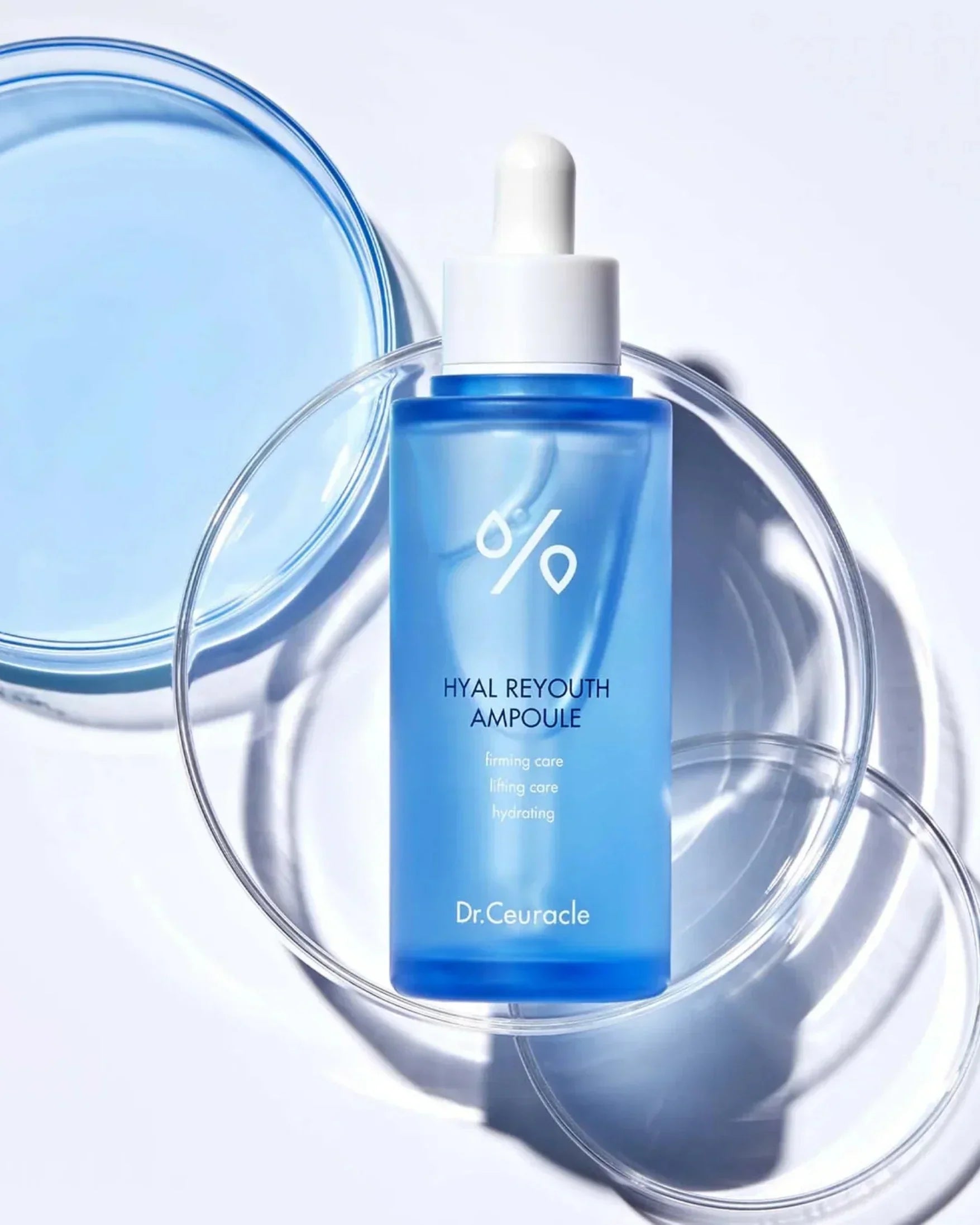 Dr.Ceuracle Hyal Reyouth Ampoule bottle with dropper on clear petri dishes, skincare serum