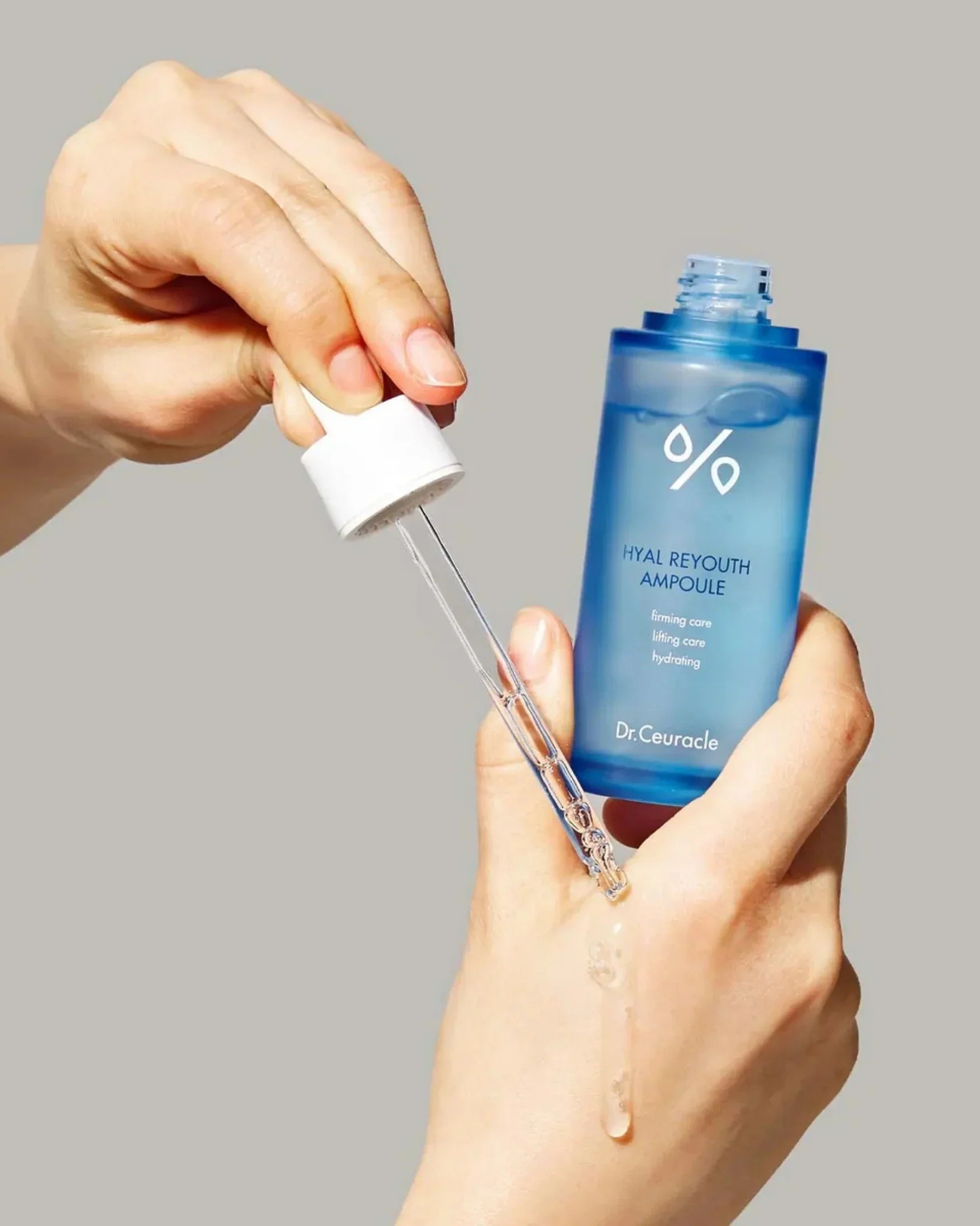 Hand applying Dr. Ceuracle Hyal Reyouth Ampoule serum with dropper on skin