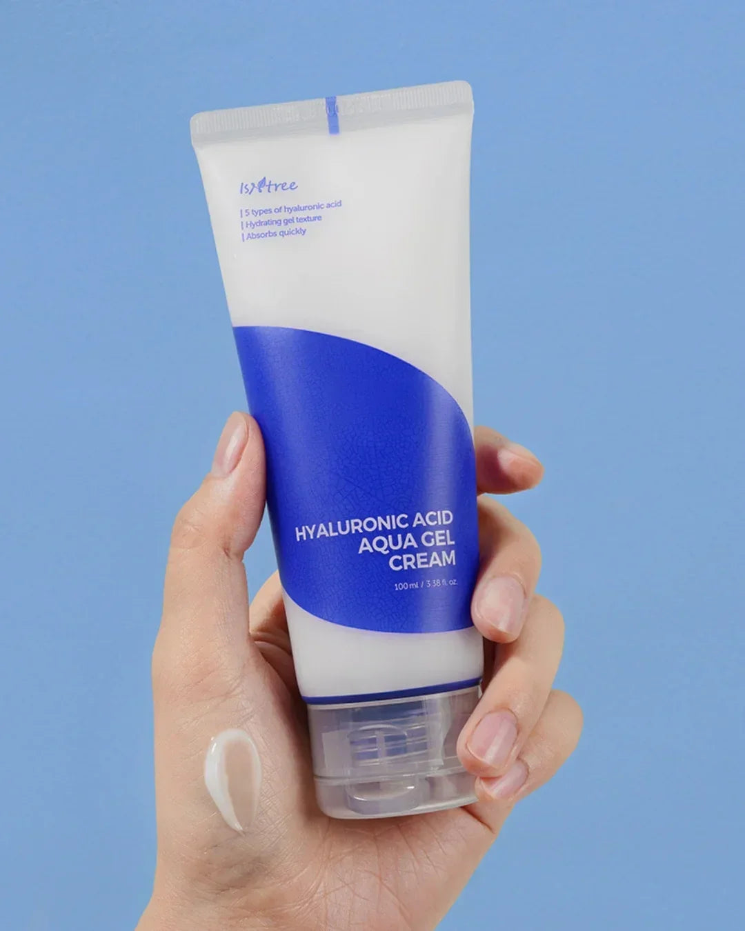 Hand holding Isntree Hyaluronic Acid Aqua Gel Cream tube with cream dab on back of hand