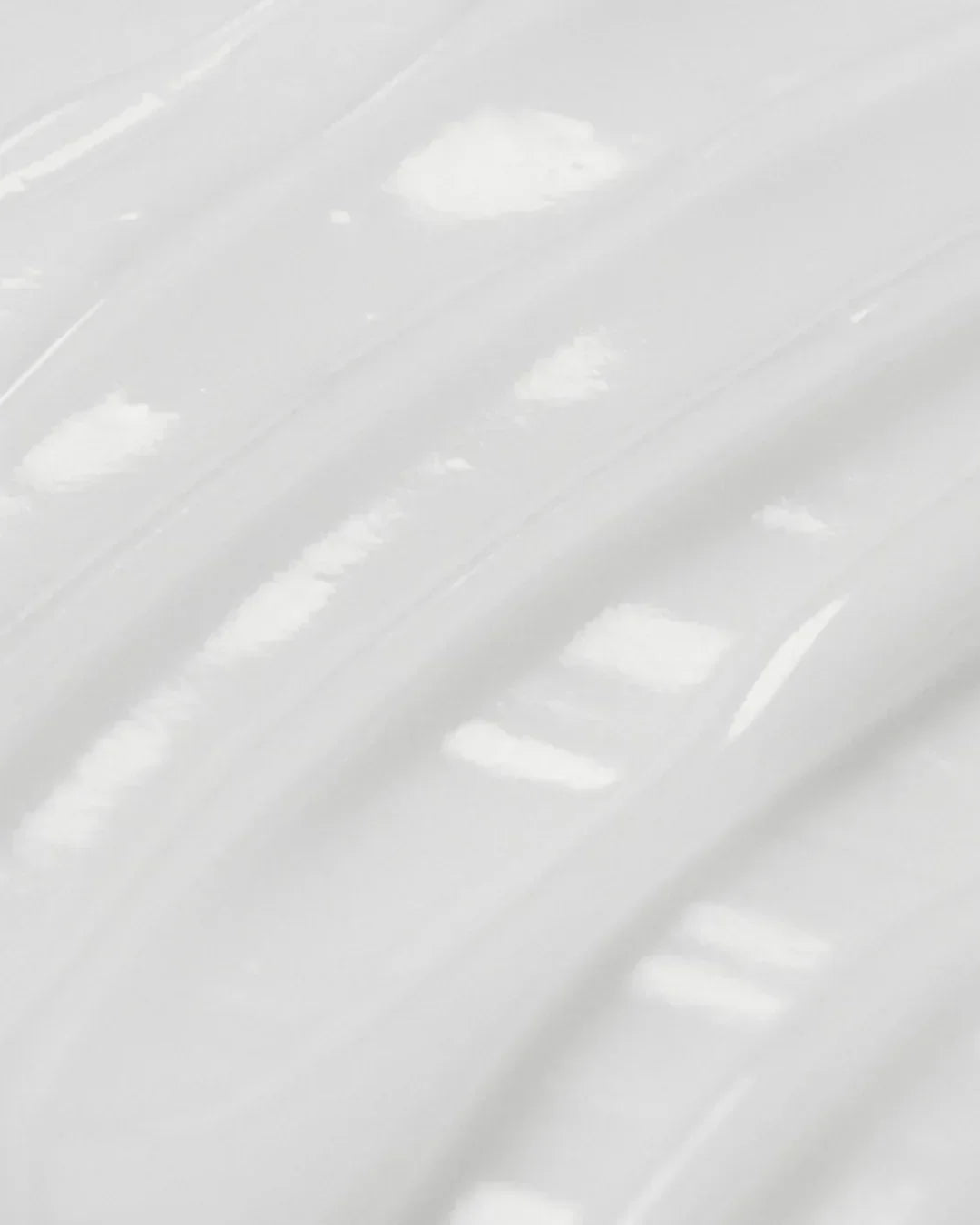 Close-up texture of smooth, glossy white hyaluronic acid aqua gel cream