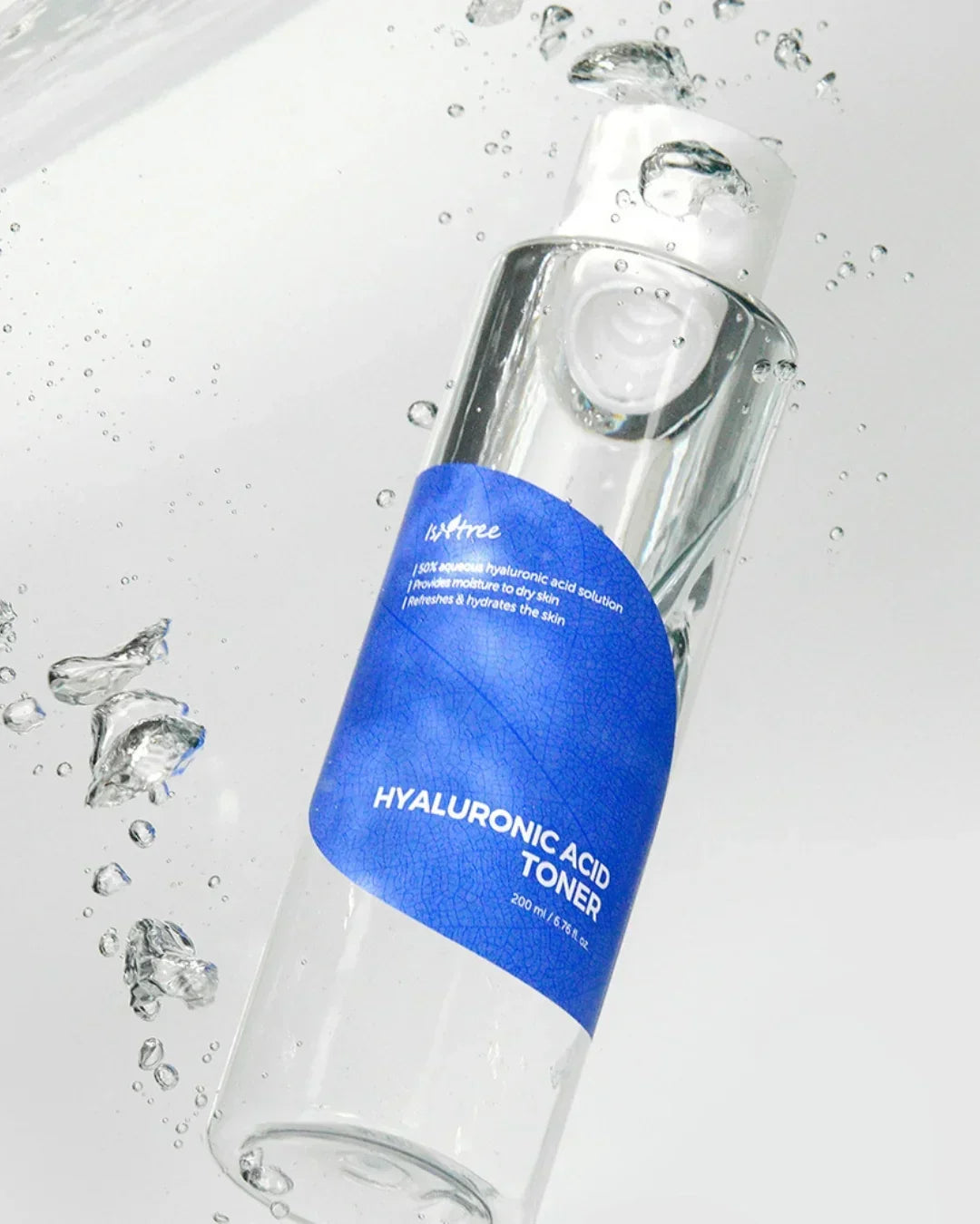 Hyaluronic acid toner bottle with blue label submerged in clear water with bubbles