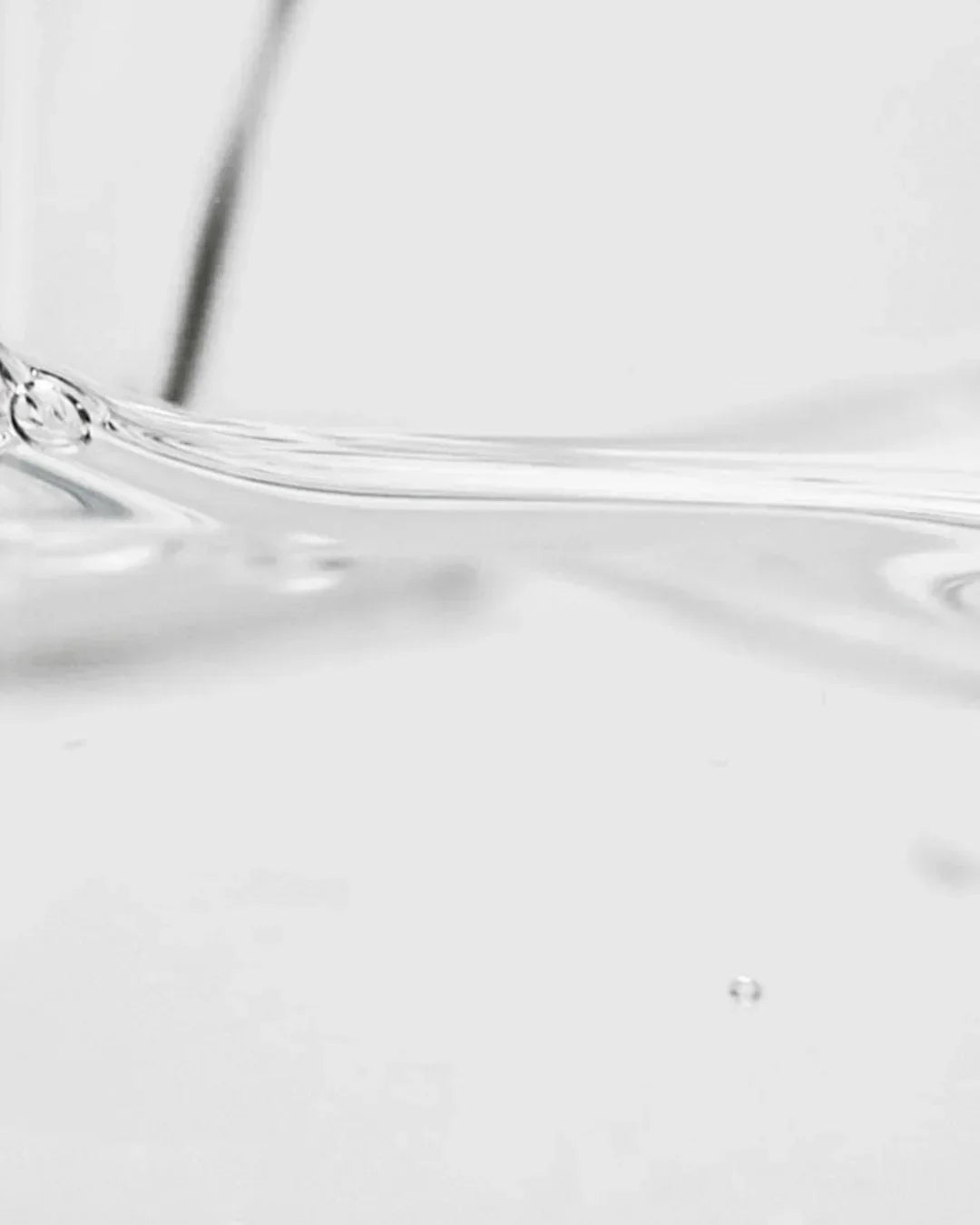 Close-up of clear hyaluronic acid serum texture with smooth, glossy liquid surface