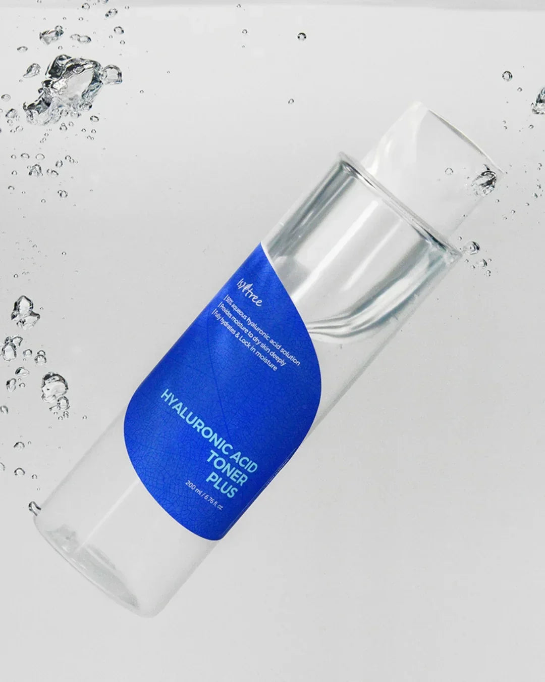 Clear bottle of hyaluronic acid toner plus 200ml with blue label floating in water with splashes