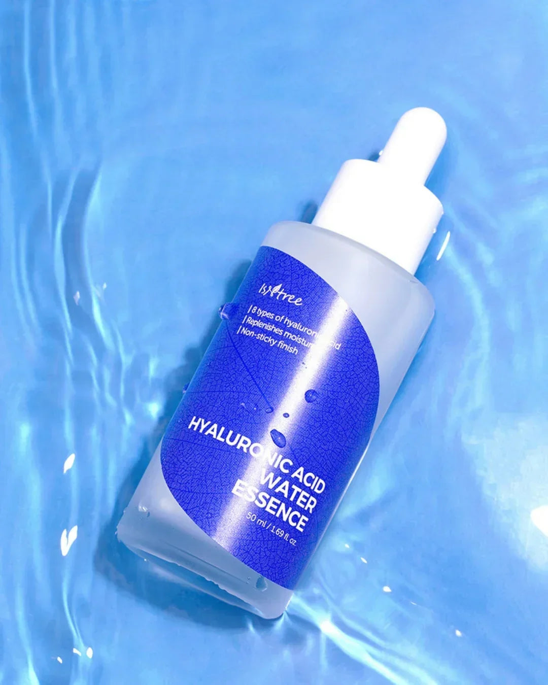 Isntree Hyaluronic Acid Water Essence bottle on blue water surface with ripples