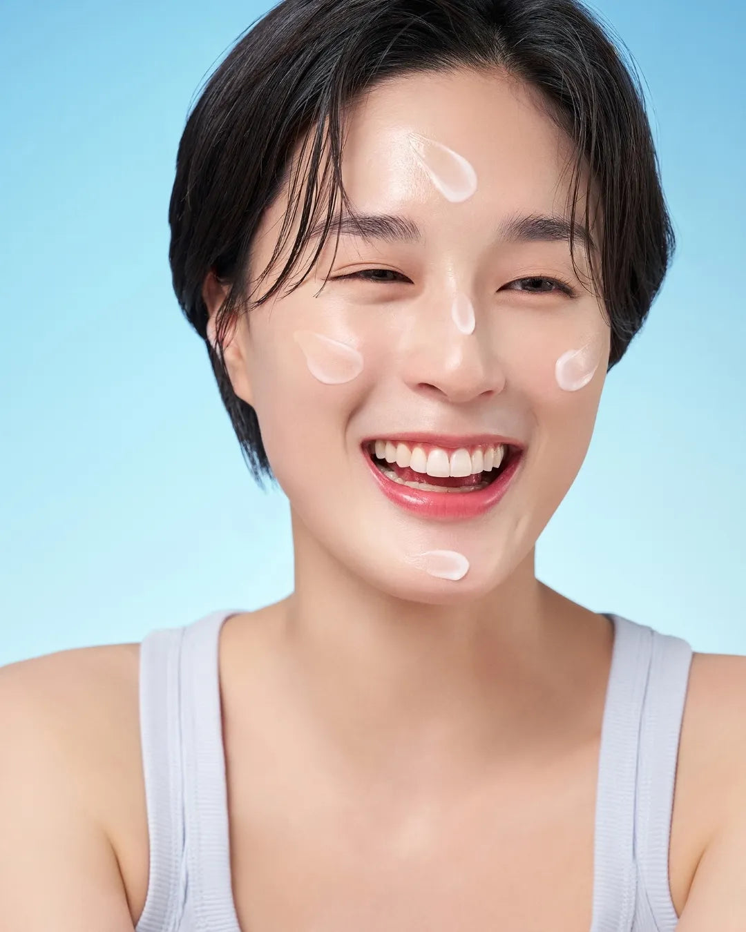 Woman smiling with PURITO SEOUL Hydro Wave Deep Sea Serum applied to her face.