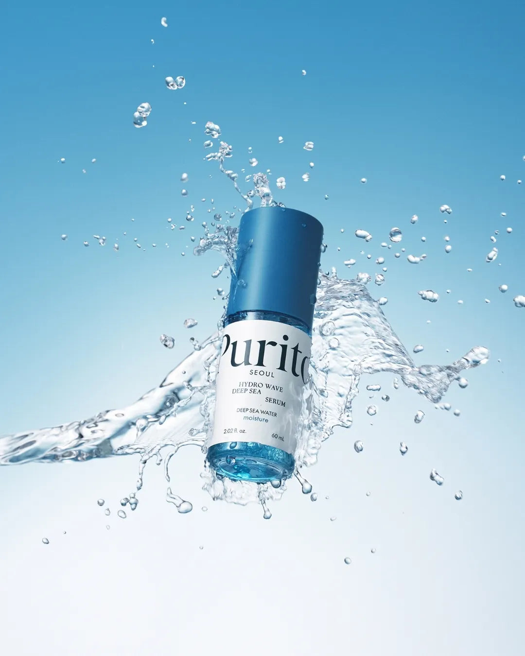 PURITO SEOUL Hydro Wave Deep Sea Serum bottle splashing in clear blue water.