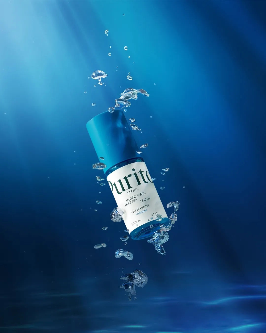 PURITO SEOUL Hydro Wave Deep Sea Serum bottle floating in deep blue water with bubbles.