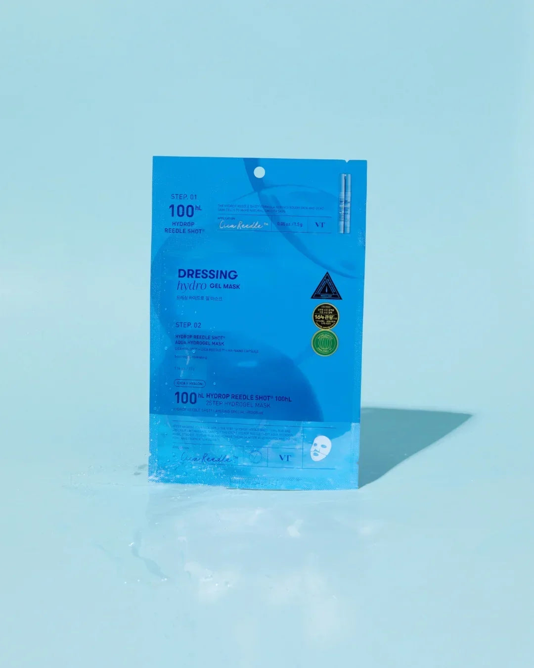 Blue packaging of VT Dressing Hydro Gel Mask with water splash on light blue background