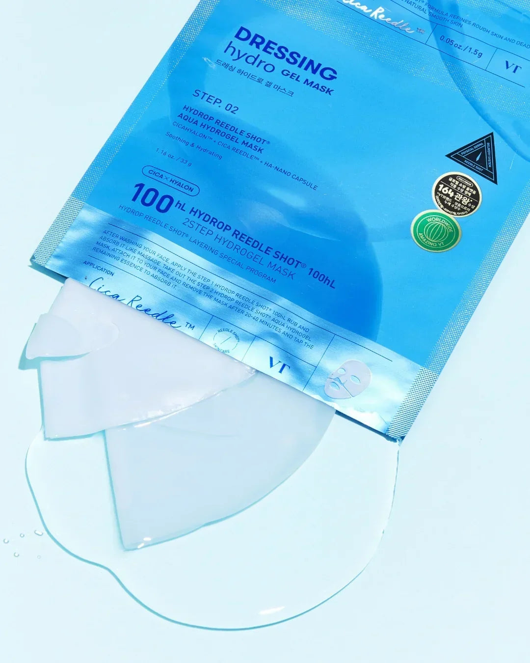 Blue packaging of VT Dressing Hydro Gel Mask with clear hydrogel mask partially pulled out on light blue background