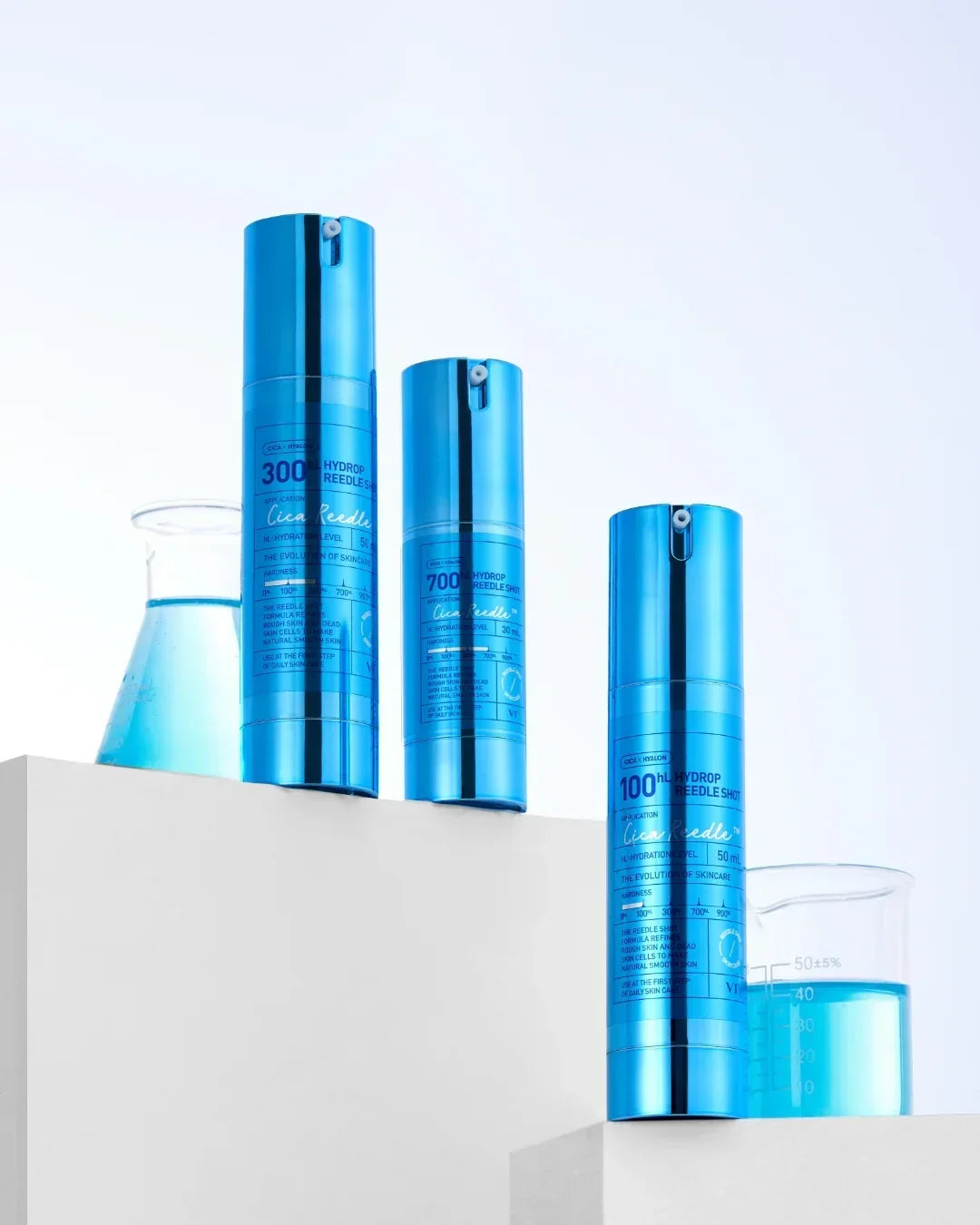 Blue hydrop needle shot skincare bottles on white pedestals with lab beakers containing blue liquid