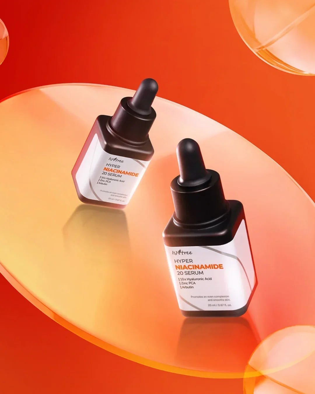Isntree Hyper Niacinamide 20 Serum bottles on a reflective orange surface with liquid drops