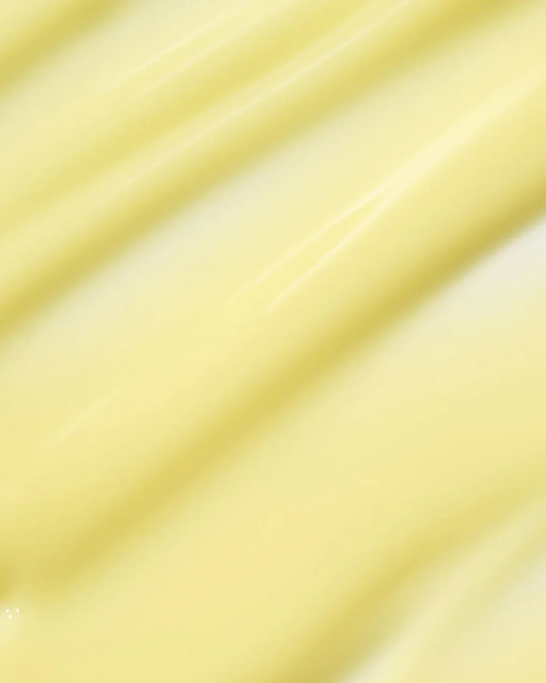 Close-up of smooth, creamy yellow serum texture with subtle glossy streaks