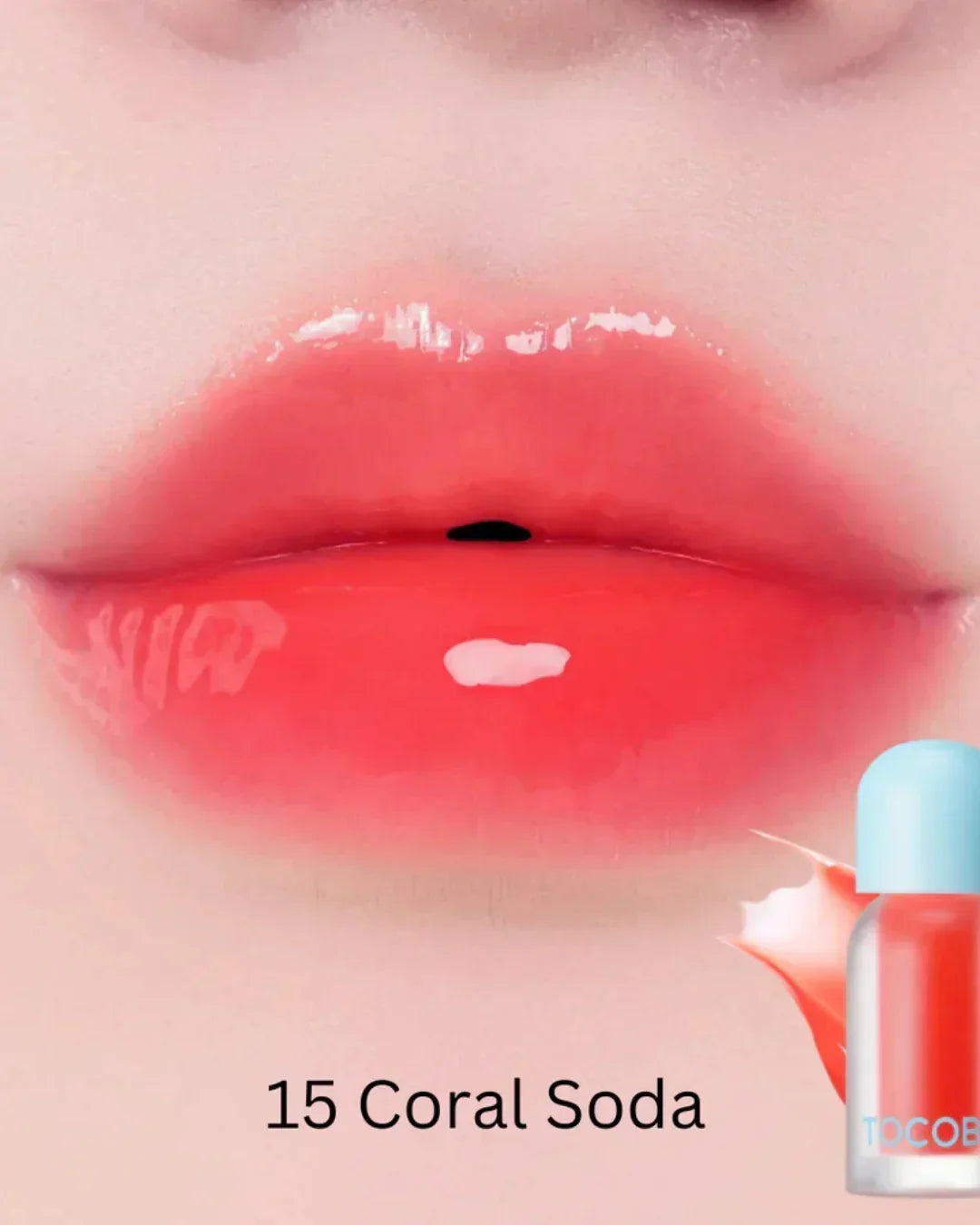 Close-up of glossy lips wearing coral soda plumping lip oil, shade 15, with lip oil bottle