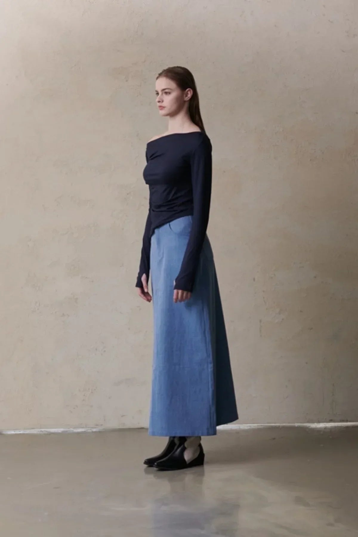 Model wearing navy off-shoulder long-sleeve top and high-waist blue maxi skirt with black shoes