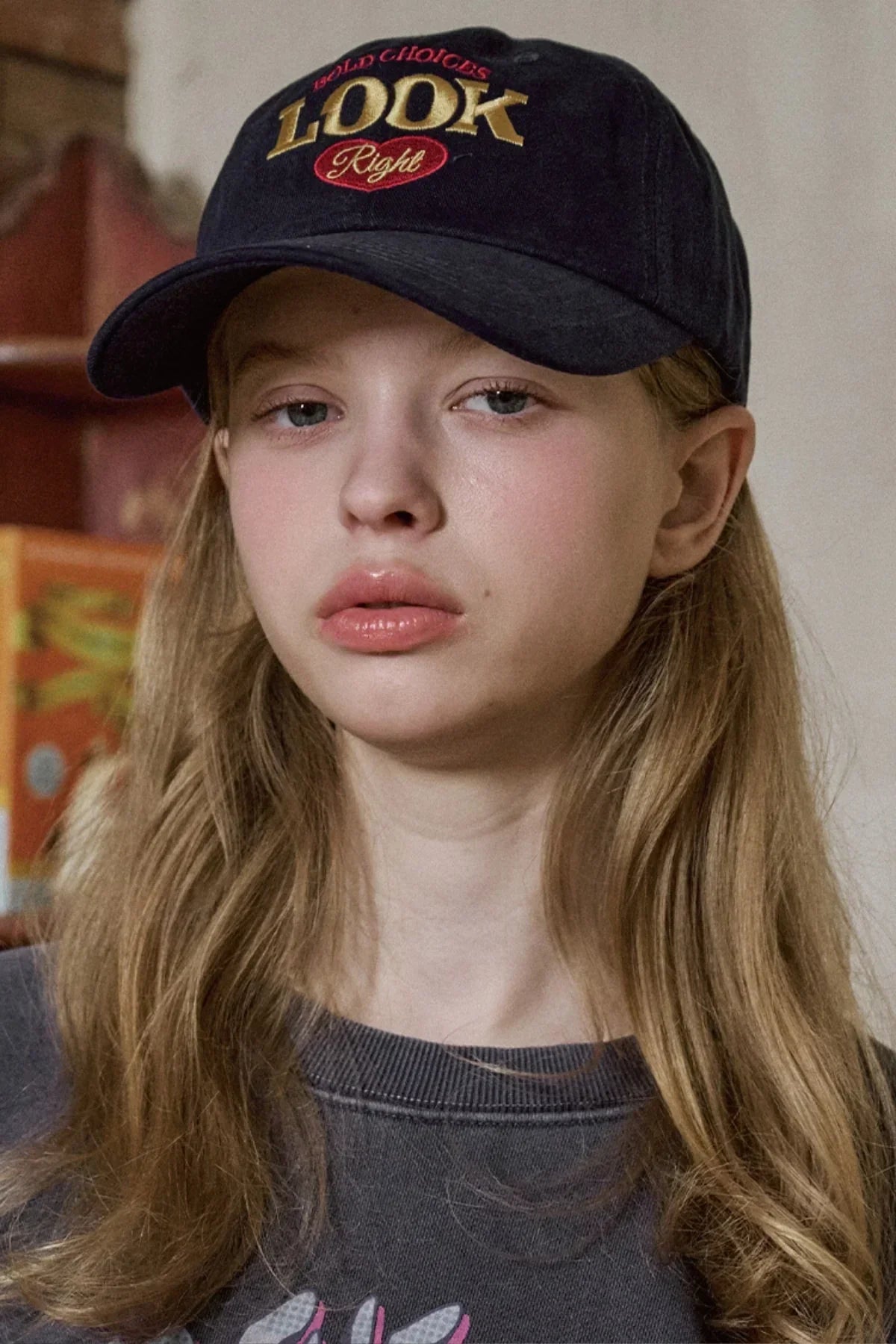 Young woman wearing navy ballcap with LOOK Right embroidery and long blonde hair