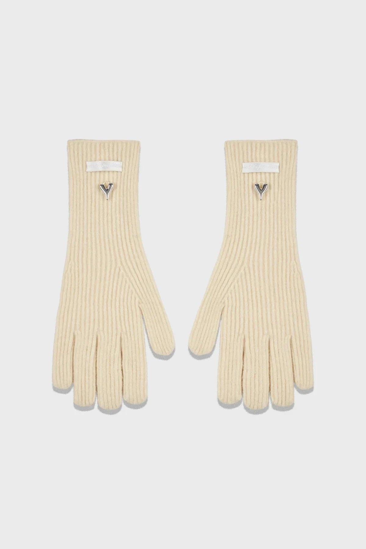 Cream ribbed knit gloves with silver heart charm and white label on wrist