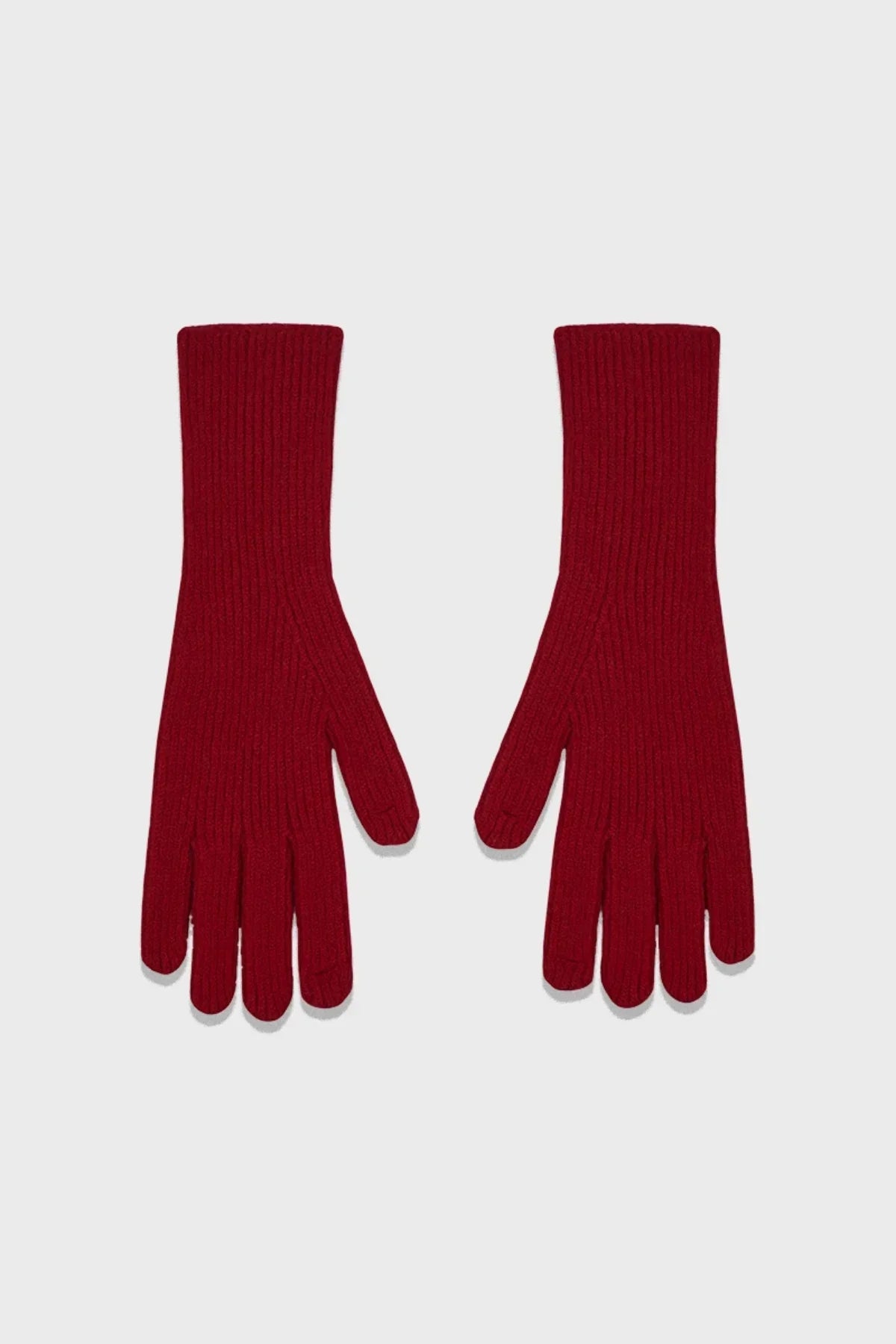 Pair of red ribbed knit gloves laid flat on a light gray background