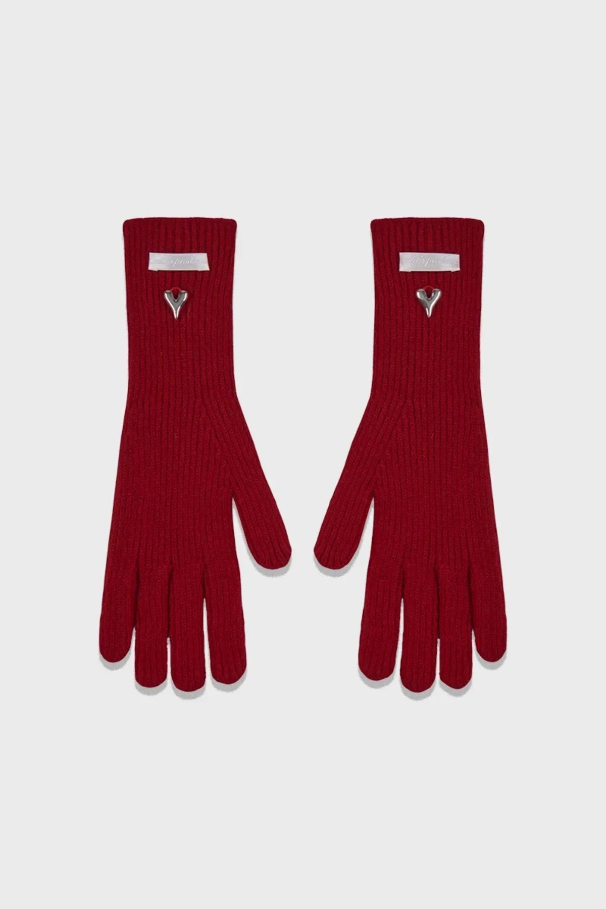 Pair of red ribbed knit gloves with metallic heart embellishment and white label on cuffs